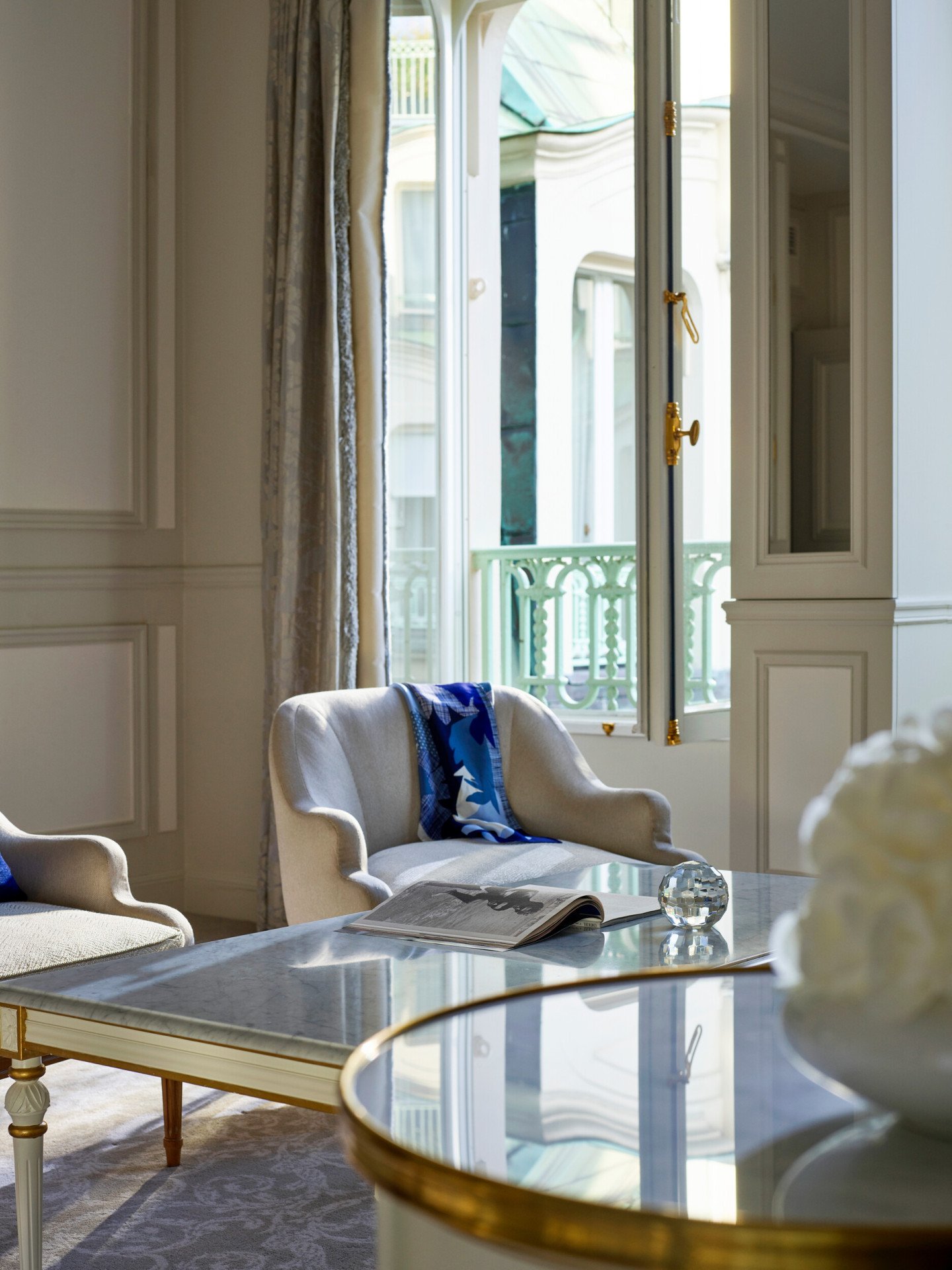 Sala de estar de uma suite de luxo com destaque para a janela aberta no Le Meurice, Paris.