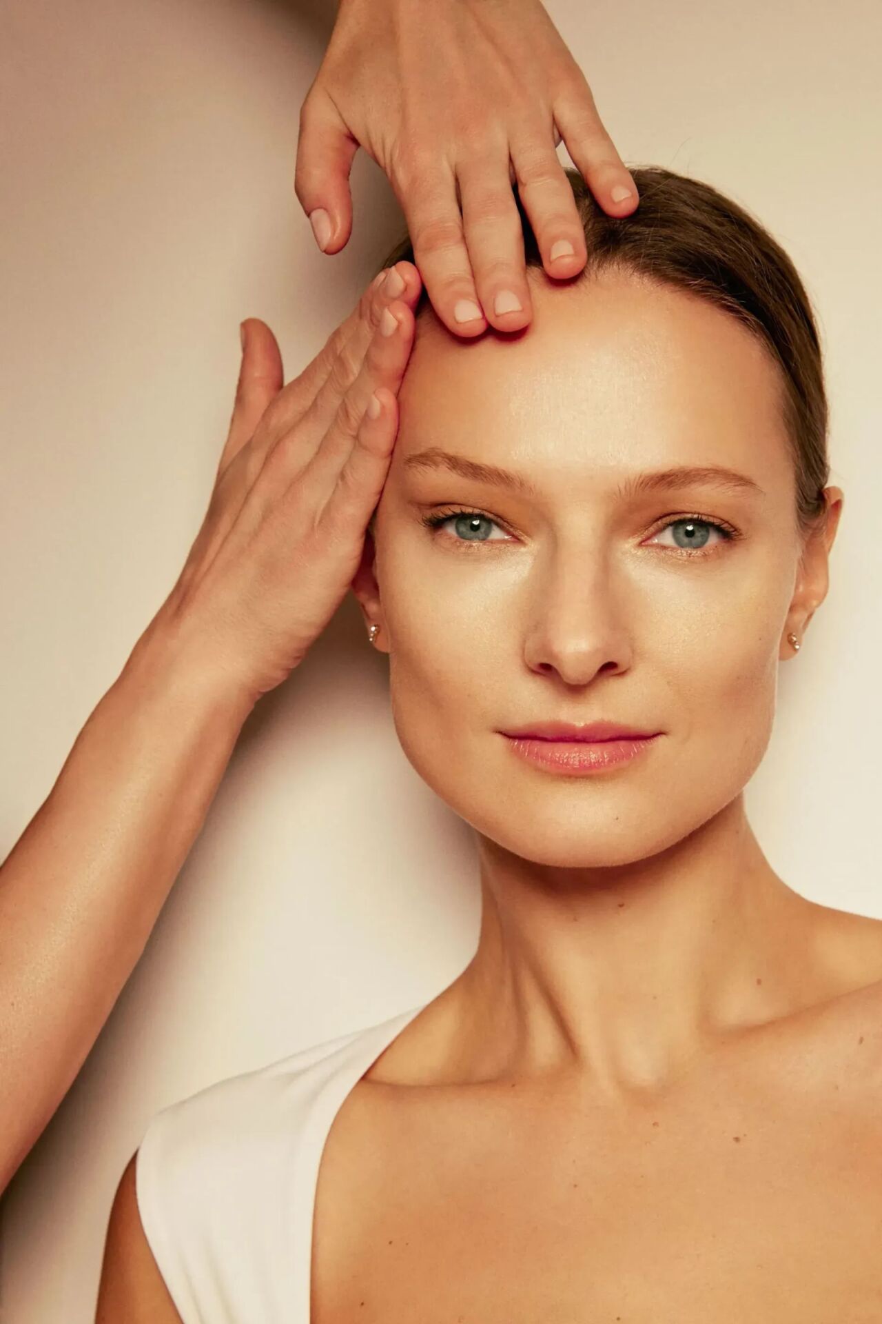 Model receiving treatment for spa masterclass demonstration for Natura Bissé in warm lighting
