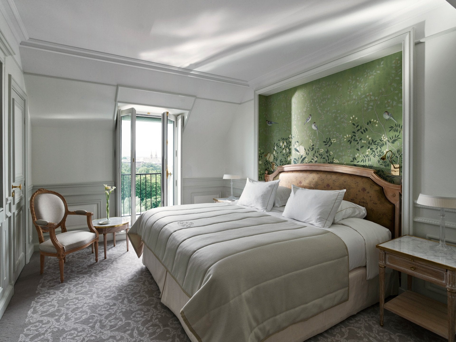 Côté chambre de la chambre supérieure, avec un mur peint à la main vert et la vue sur le jardin des Tuileries au loin. Au Meurice, Paris.
