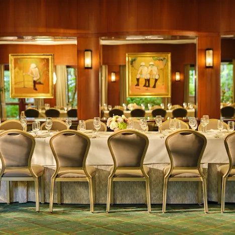Elegant banquet table set for a formal event in a warmly decorated restaurant.