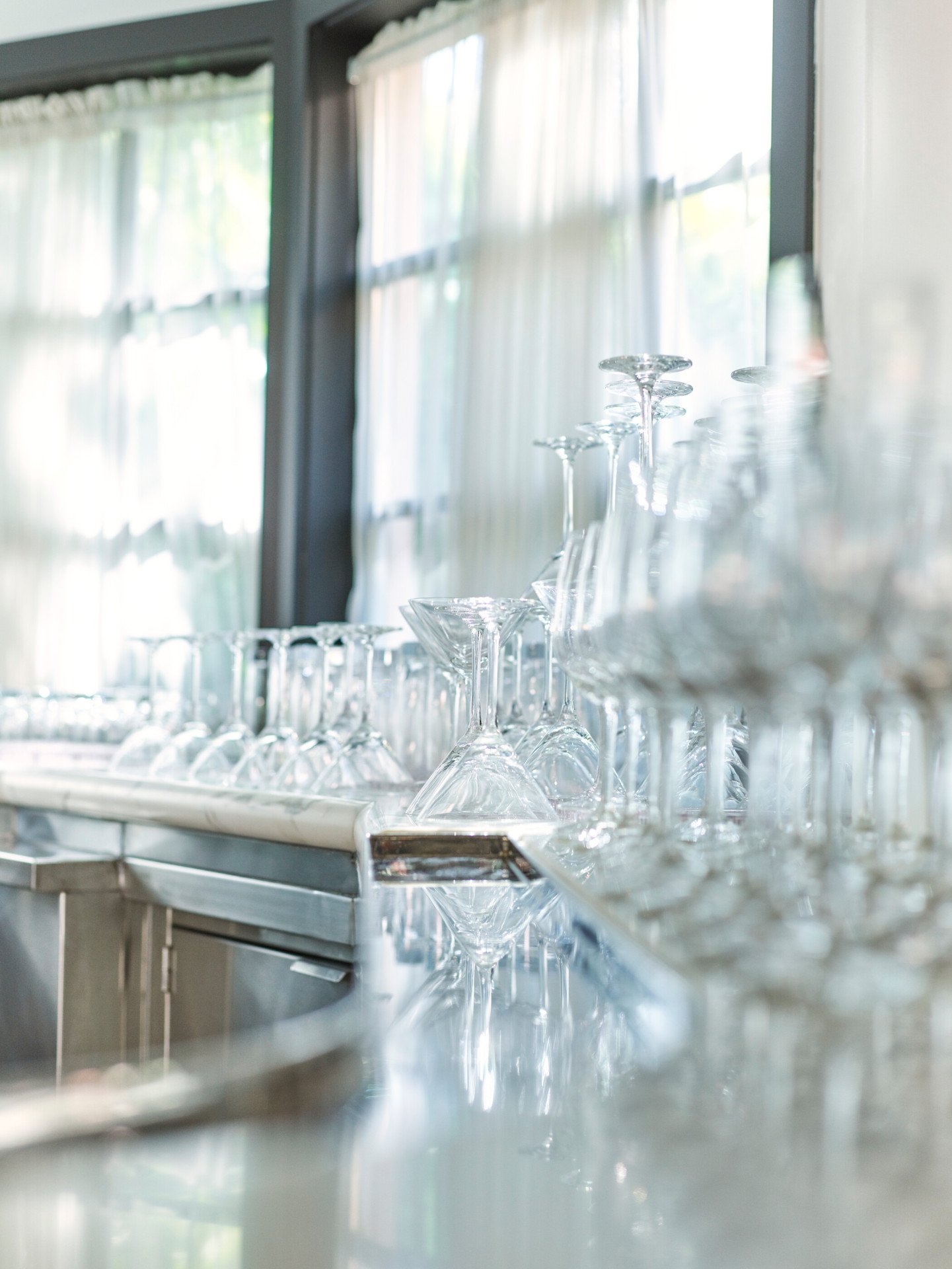 Detail glimpse of wine and champagne glasses behind the bar in the Garden Ballroom foyer event space at Hotel Bel-Air.
