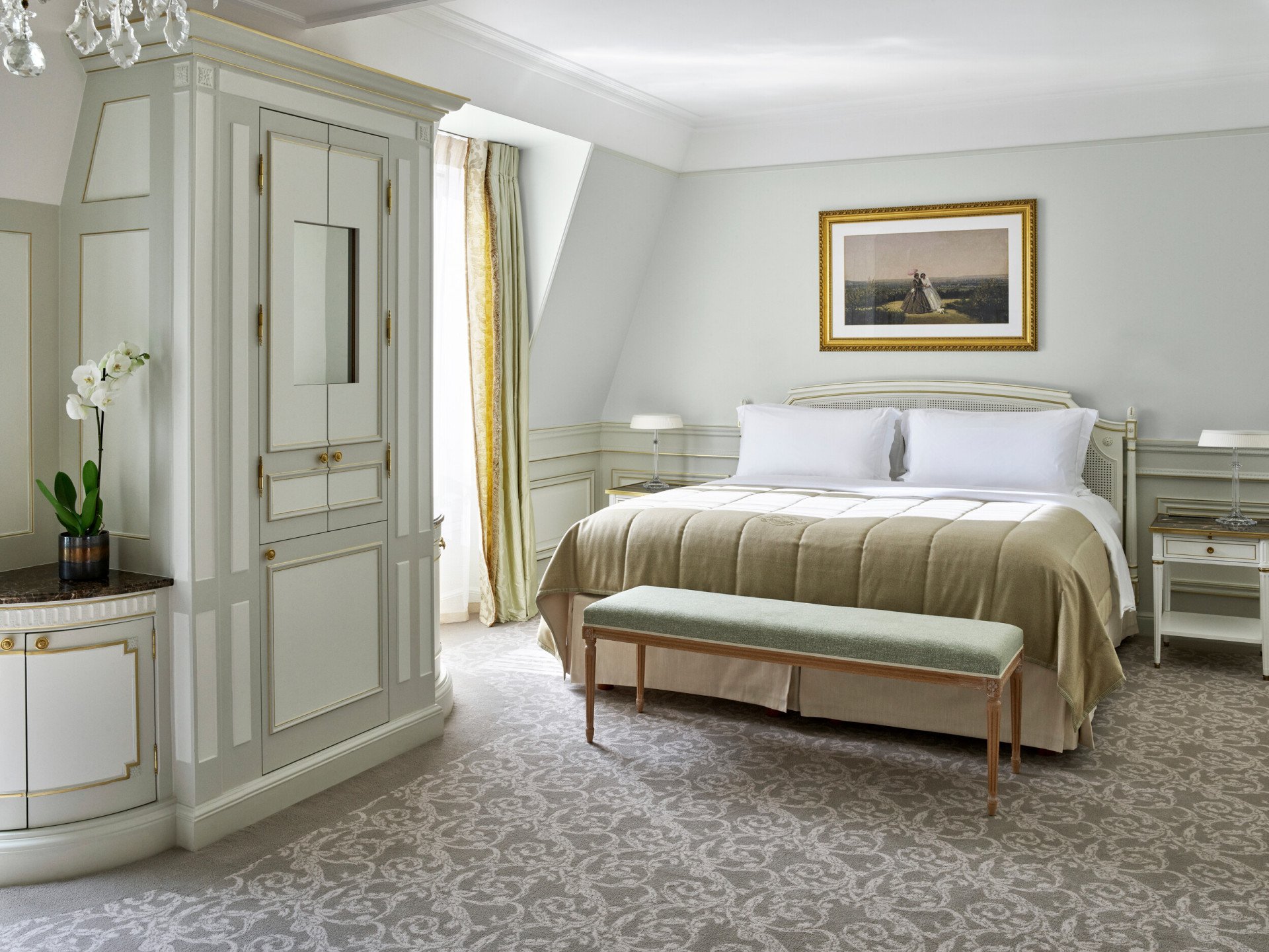 Aperçu côté chambre dans une suite junior de luxe, aux nuances vert clair au Meurice, Paris.