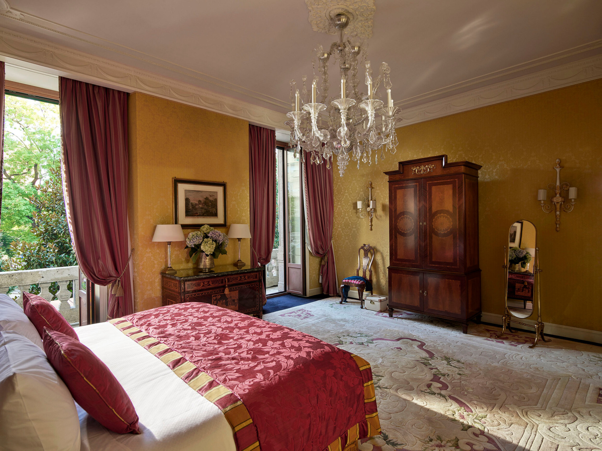 Camera da letto della Royal Suite caratterizzata dall'elegante lampadario e illuminata da luce naturale proveniente dalle due finestre 