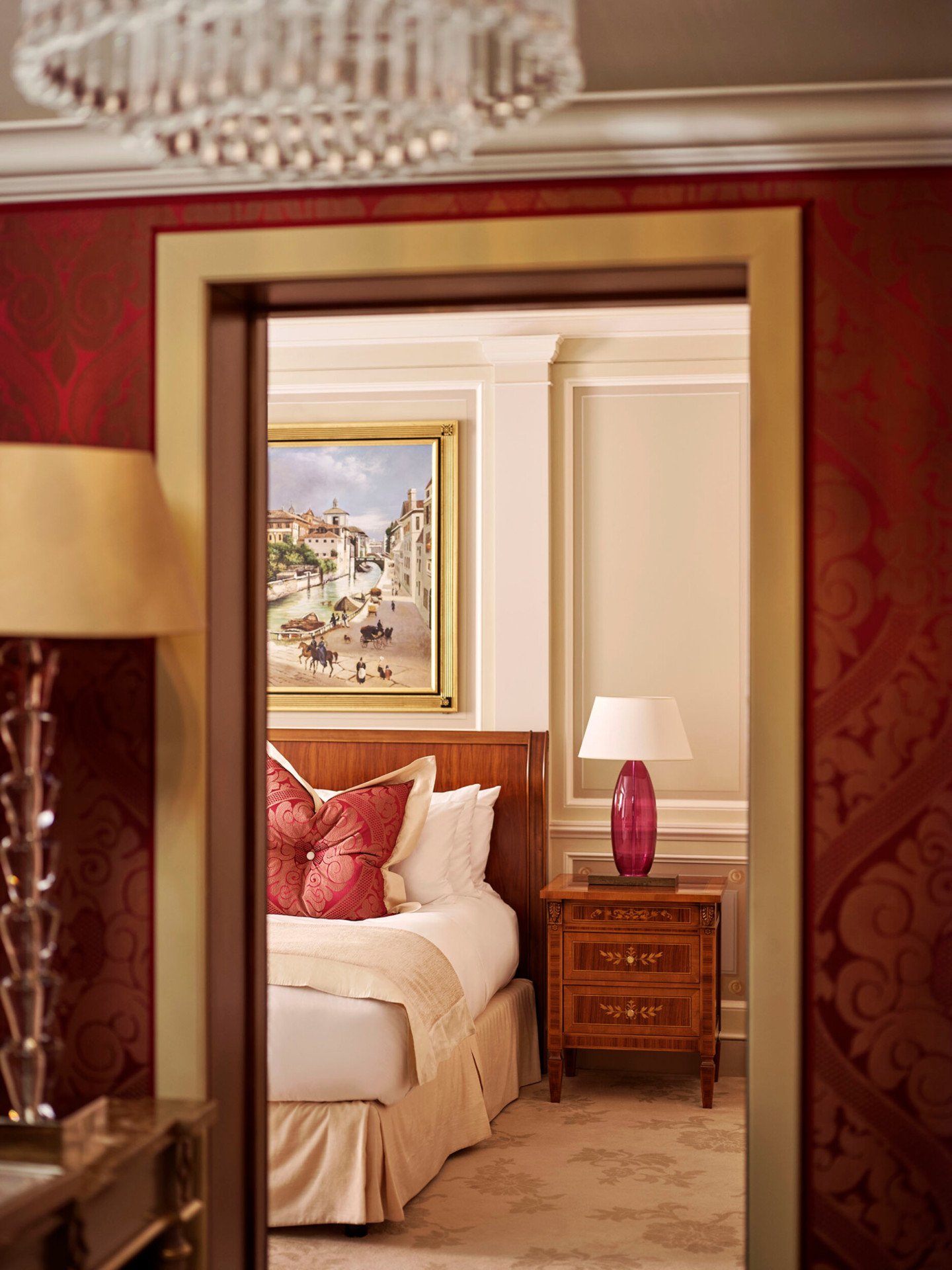 Vista parziale della camera da letto della Principe Suite che mostra parte del letto king size e il grande dipinto sopra la testiera del letto