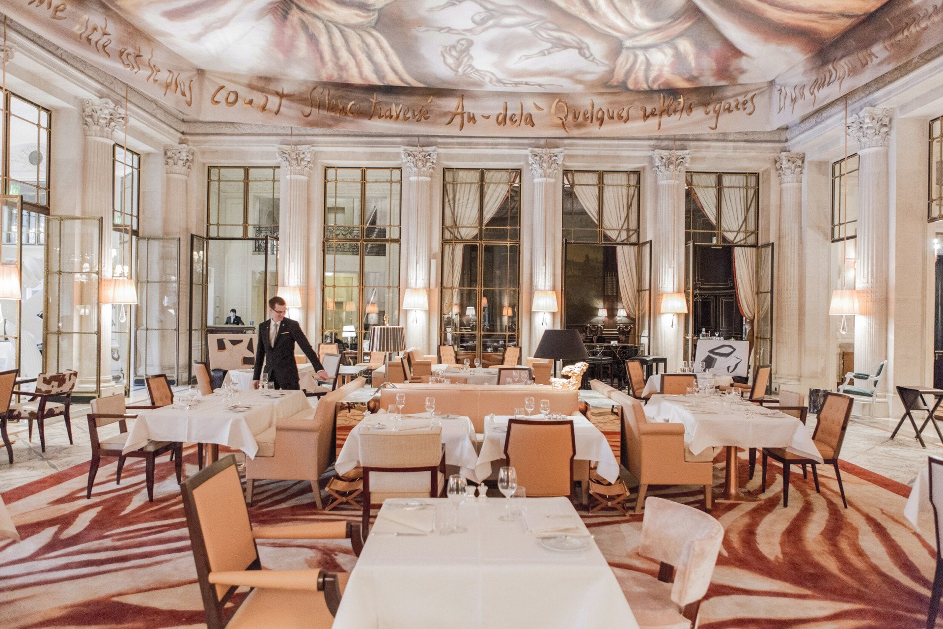 Overview shot of the restaurant room with a waiter in the room, at Restaurant le Dali at Le Meurice, Paris.