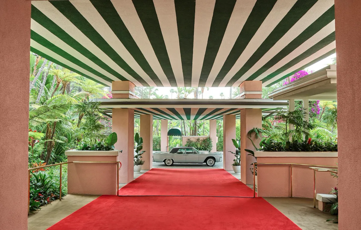 The Beverly Hills Hotel red carpet entrance facing valet direction with a blue car.