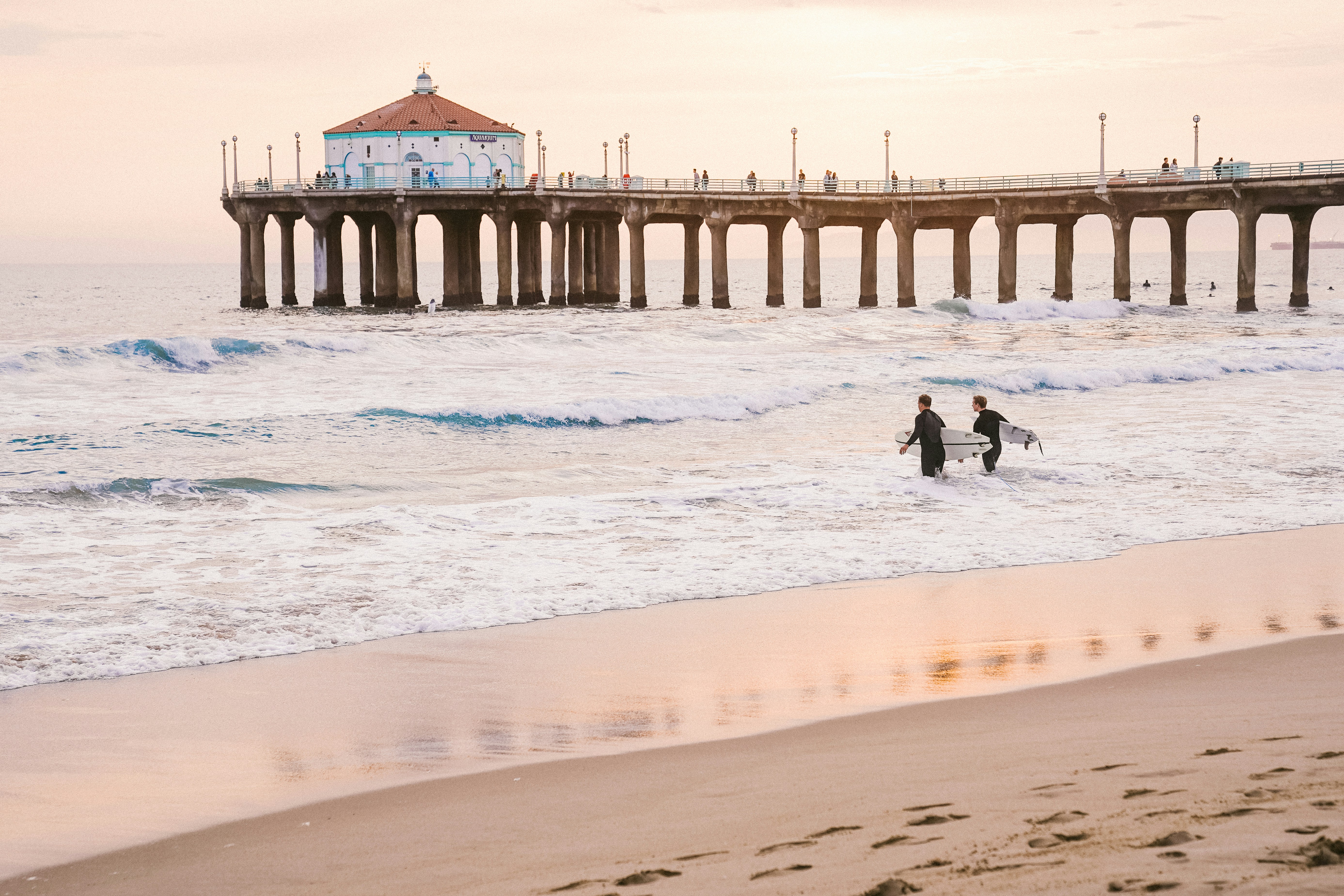 Two surfers heading to the sea at Manhattan Beach for a surfing session