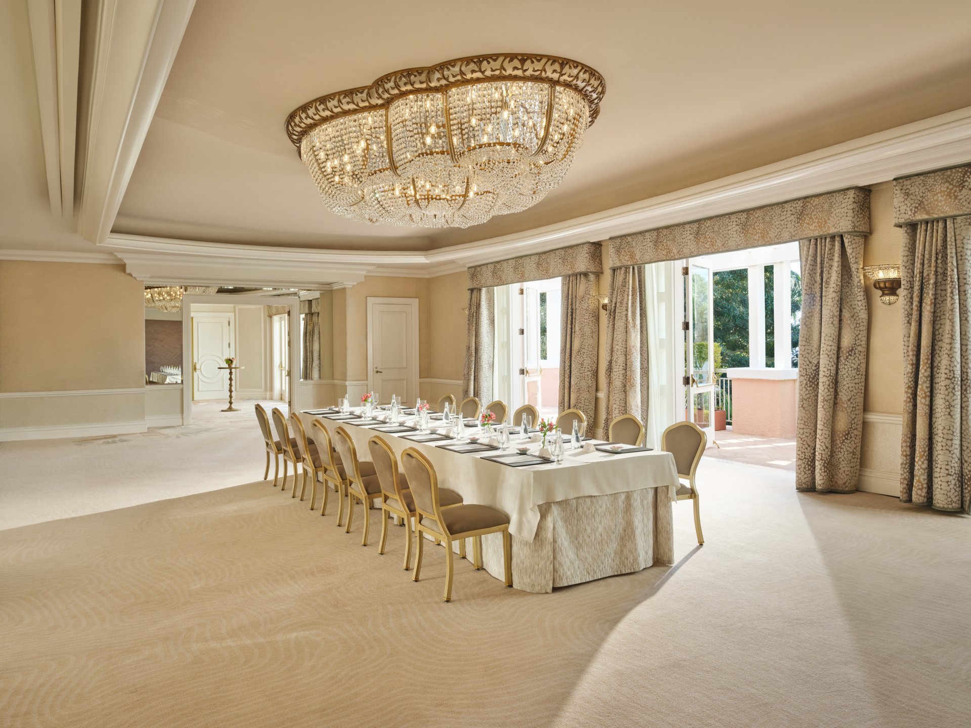 Elegant dining room with a long table set for a formal event and a large chandelier overhead