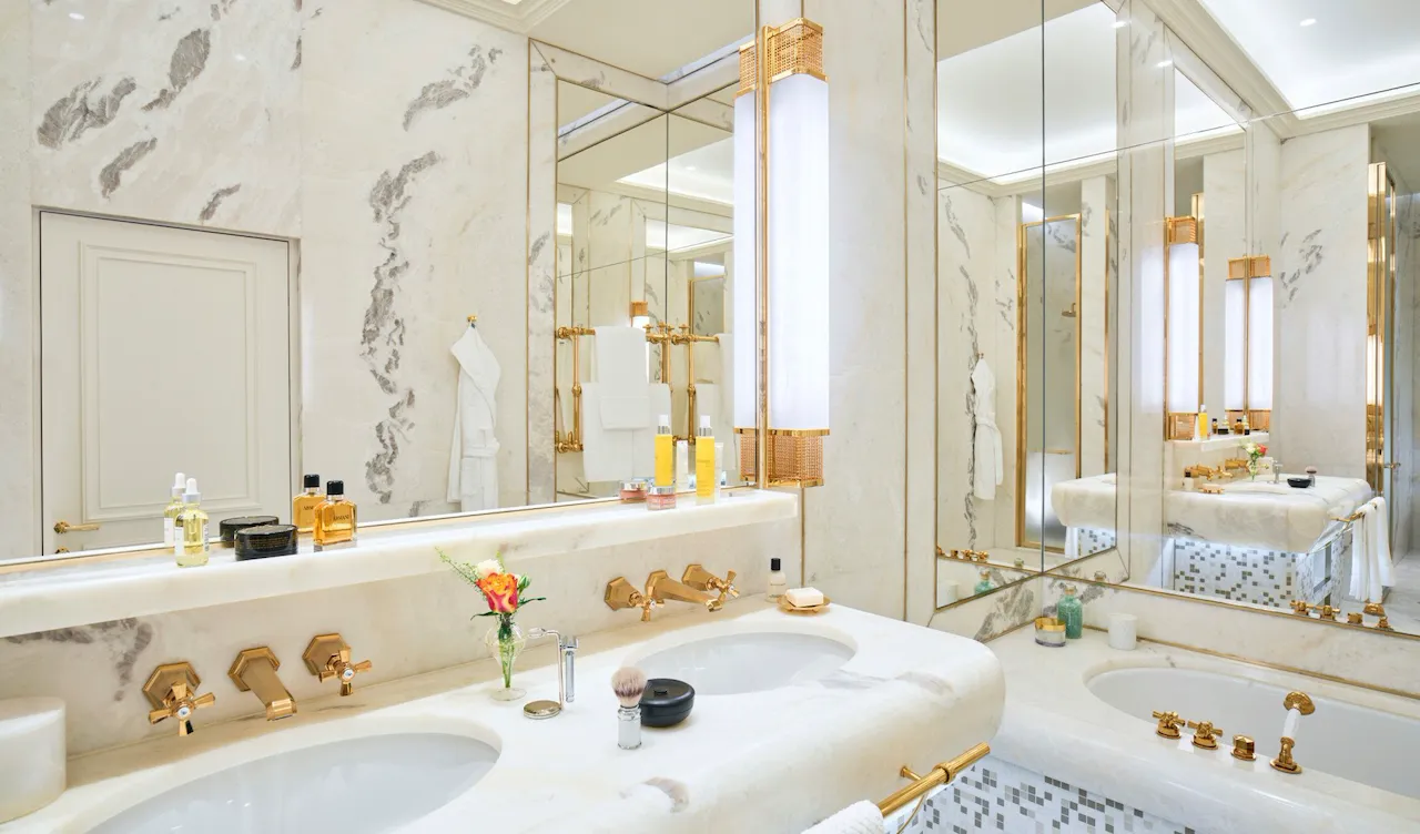 White marble bathroom of Dolce Vita Suite with double sinks, bathtub and mirrors with view of Rome at Hotel Eden