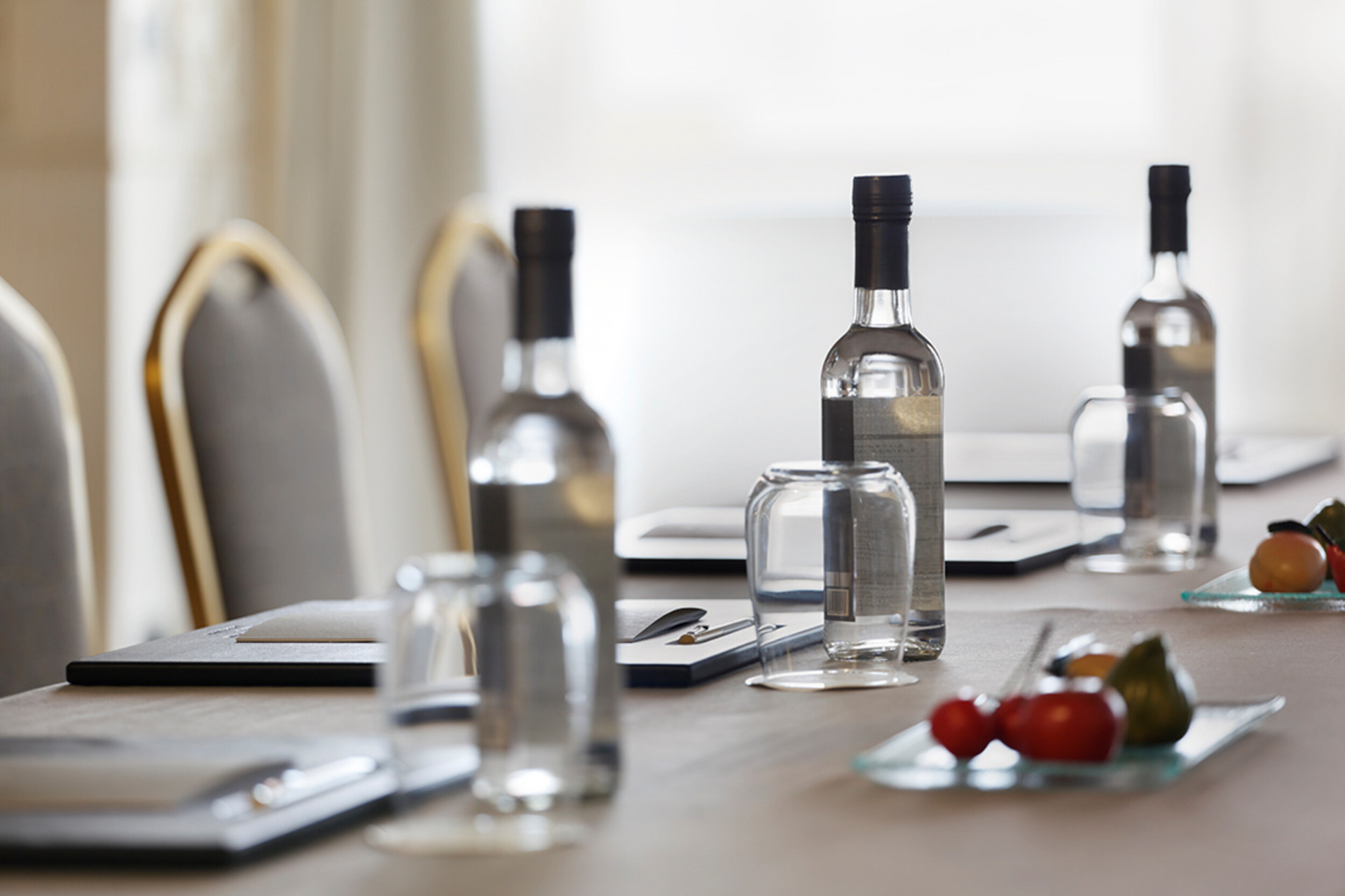 dettaglio di un tavolo di una sala riunioni con acqua, frutta e notes