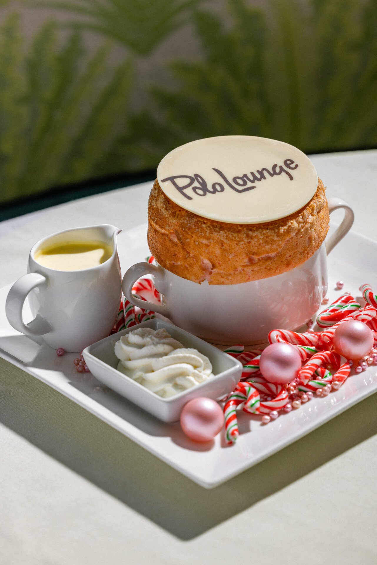Holiday peppermint flavored soufflé with pink and white candies, cream and Polo Lounge chocolate design