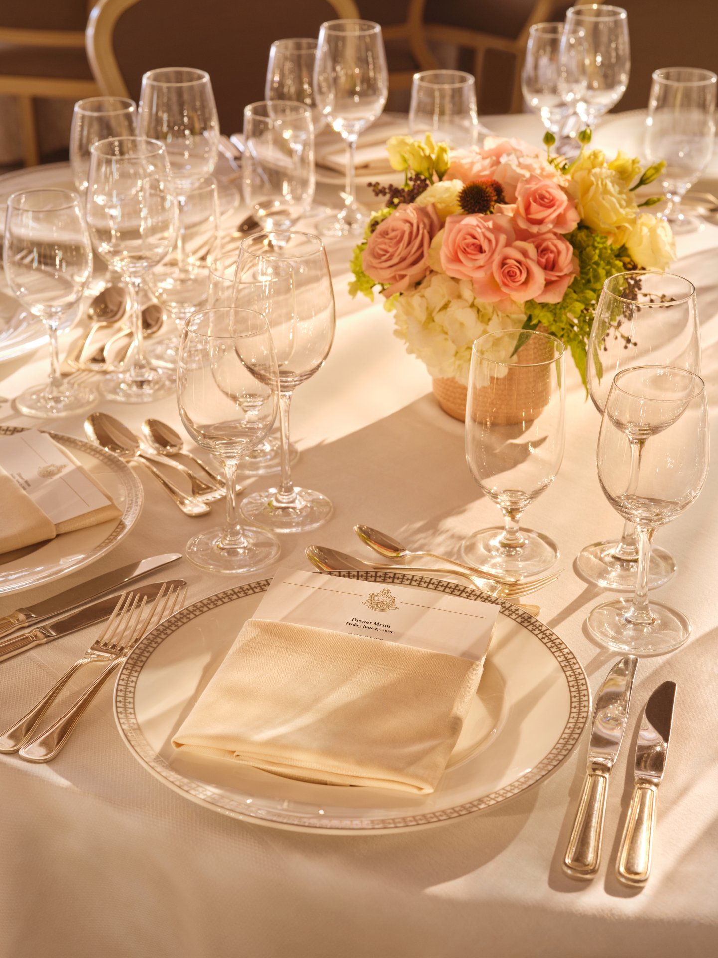 Elegant table setting with glassware, cutlery, a floral centerpiece, and folded napkins for a formal event