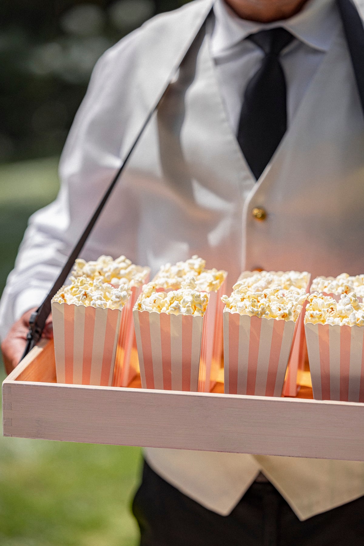 Pink and white striped popcorn boxes placed on a tray for movie nights at The Beverly Hills Hotel