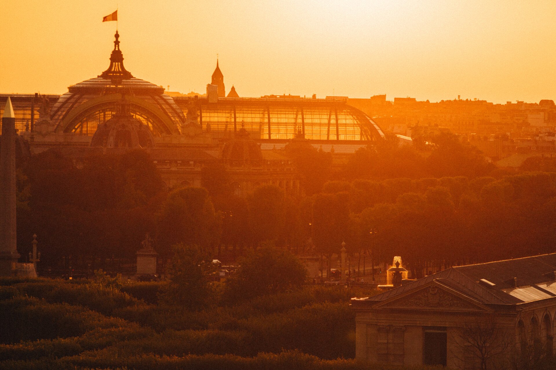 Photography of the Grand Palais from an elevated point with a sunset behind