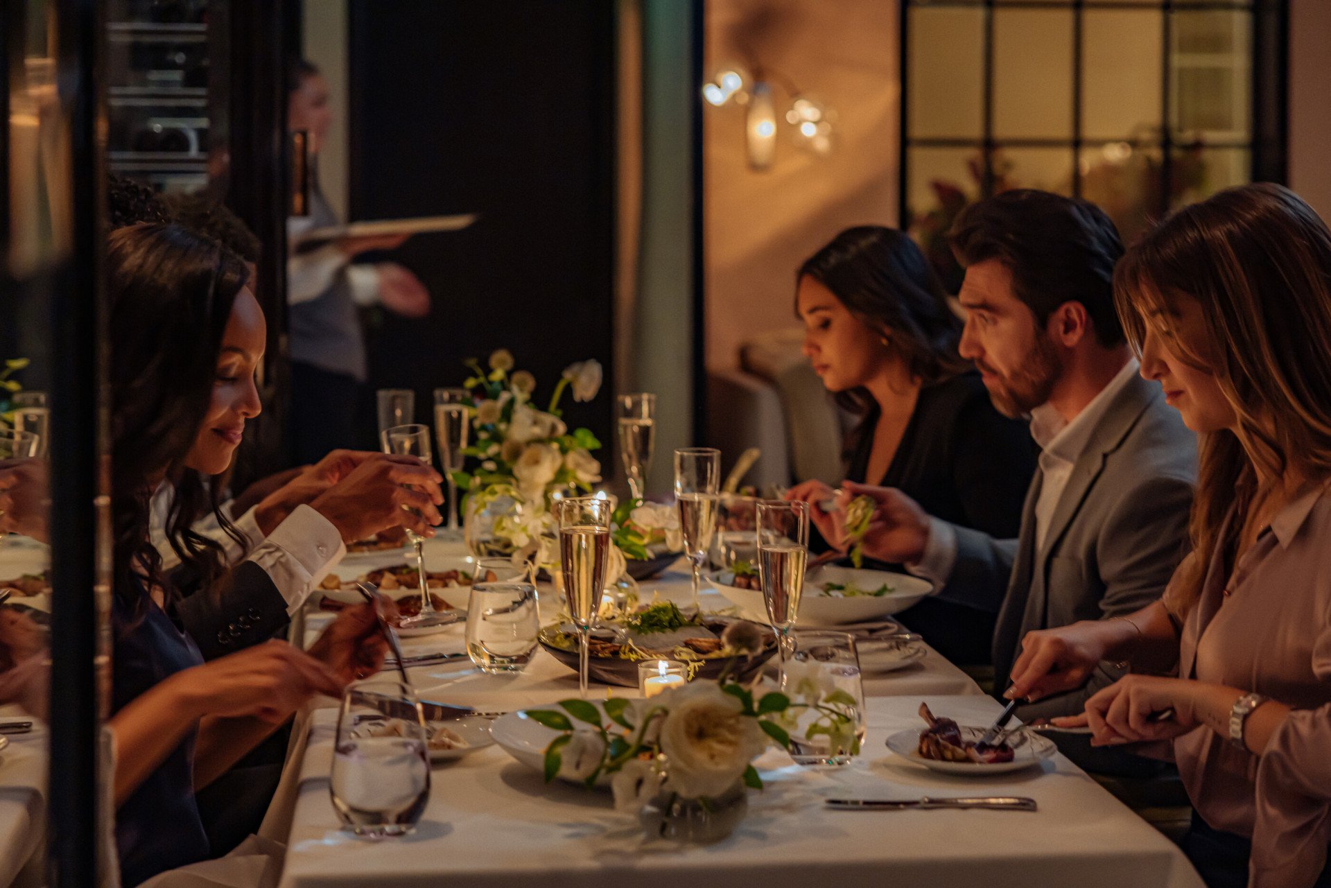 Group of people having a celebration dinner in The Restaurant at Hotel Bel-Air, Los Angeles 