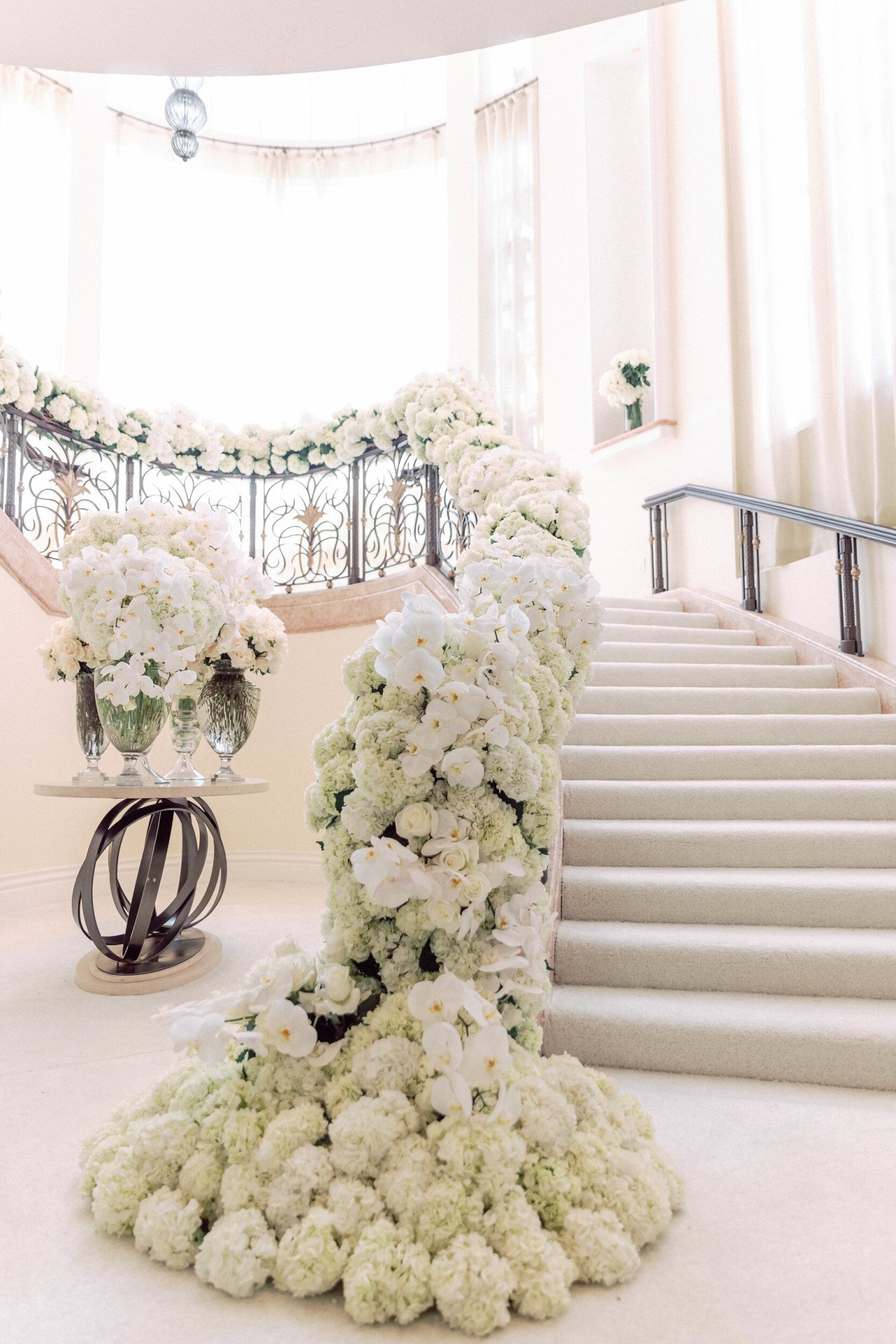 White florals cascading down grand staircase for wedding