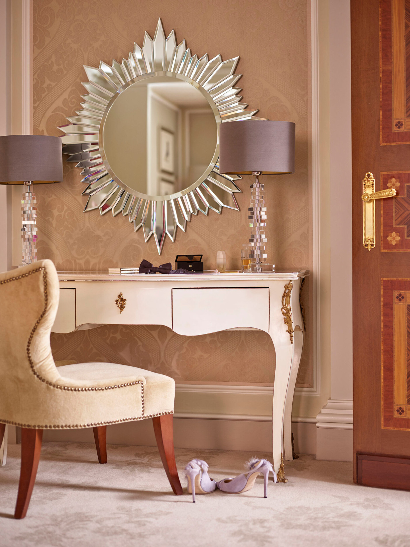 Mobile postazione trucco con uno specchio e delle lampade di design e un paio di scarpe lilla sul pavimento della Principe Suite 
