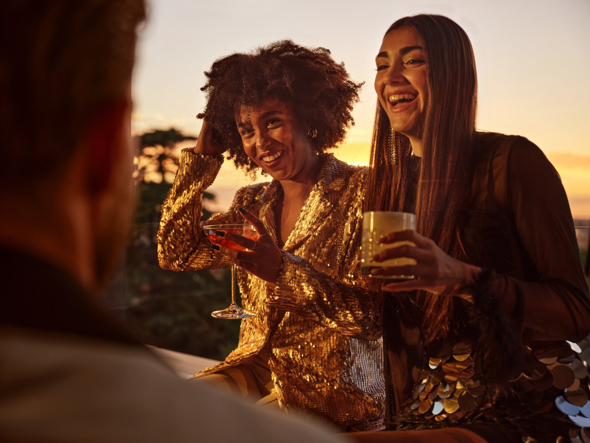 Due giovani donne sorridenti con un cocktail in mano a Il Giardino Bar