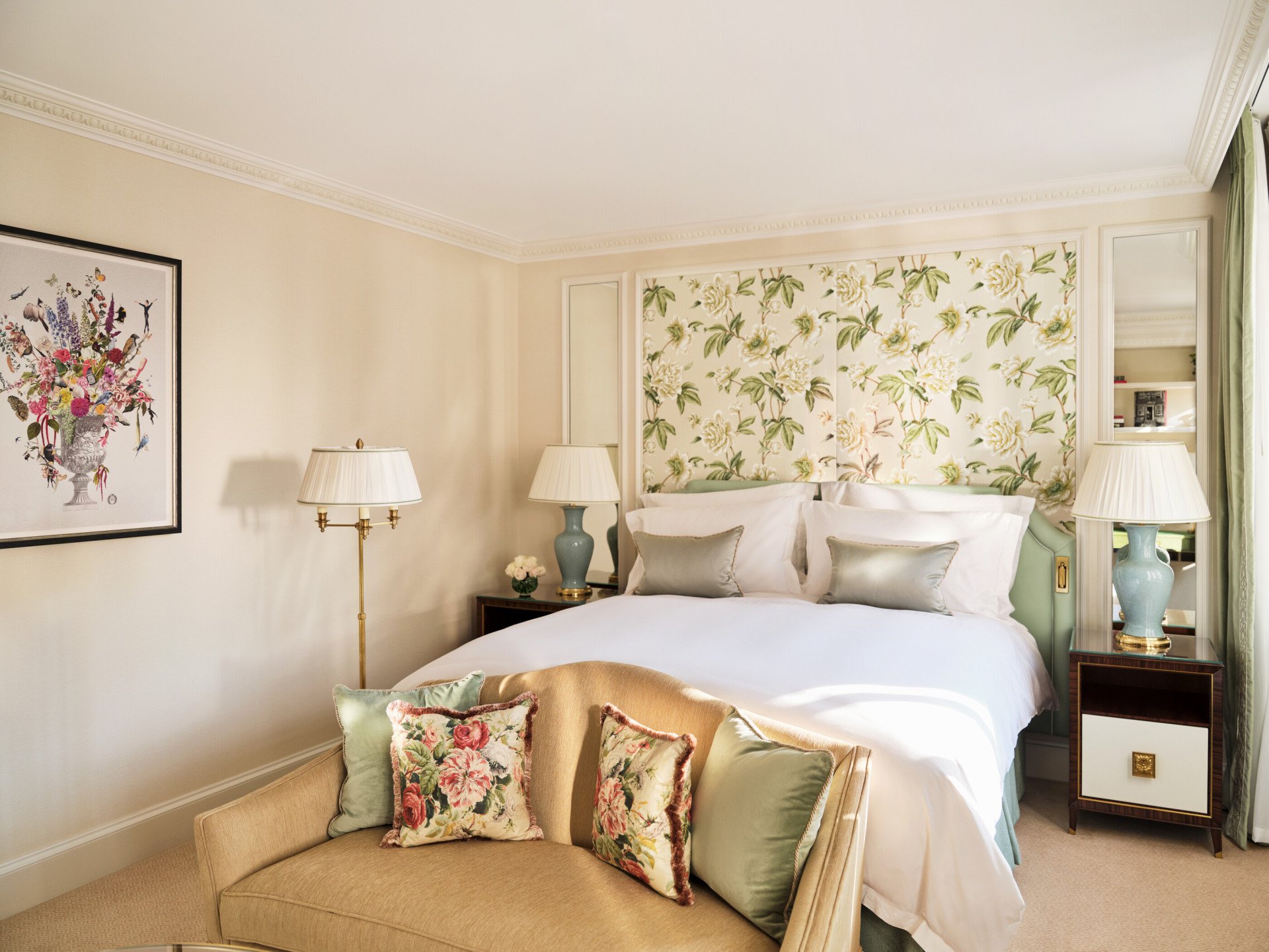 The Executive Park View Room at The Dorchester, showcasing a king-sized bed framed by botanical-inspired wall coverings, pale blue ceramic bedside lamps, bespoke bedside tables and a comfortable seating area with floral accent cushions.