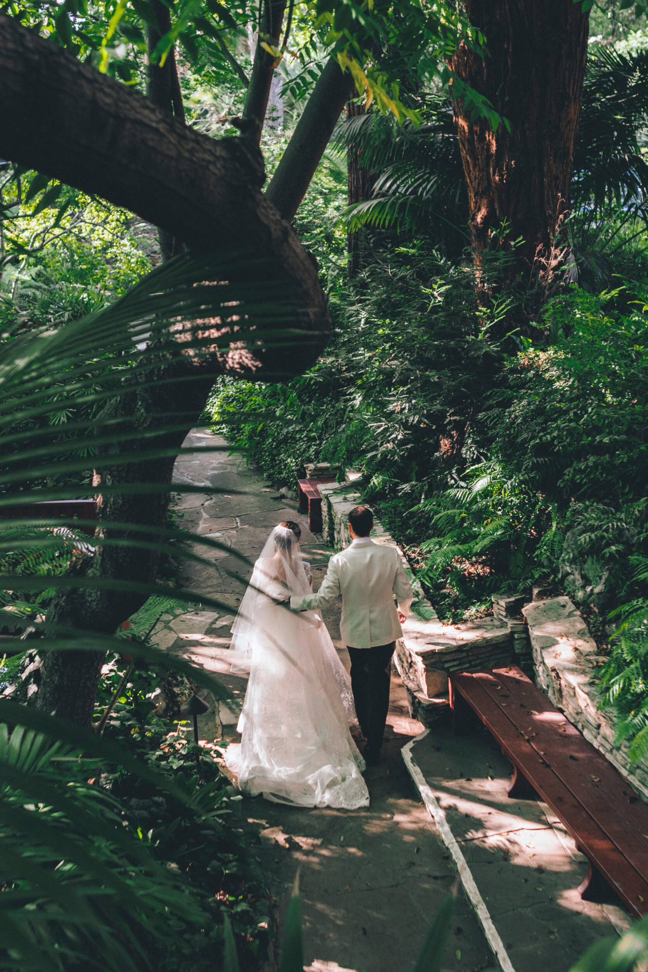 The happy couple walking hand in hand in the gardens of Hotel Bel-Air