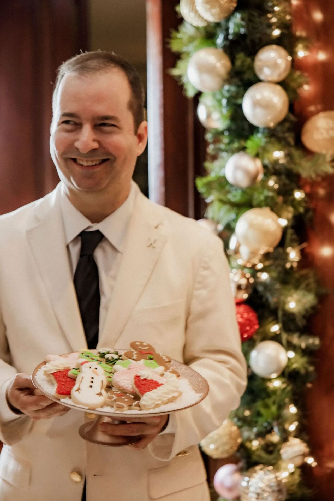 Server holding cookie display from festive cookie decorating class