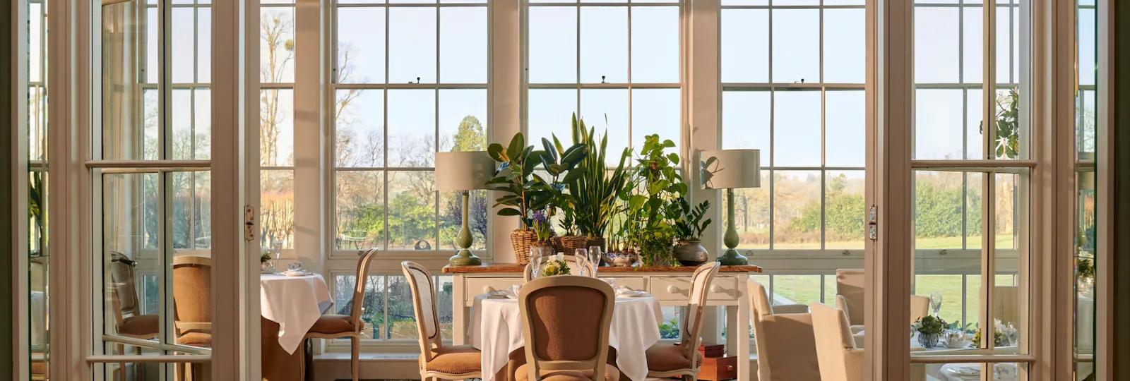 Coworth Park Drawing Room conservatory with champagne and cakes on table
