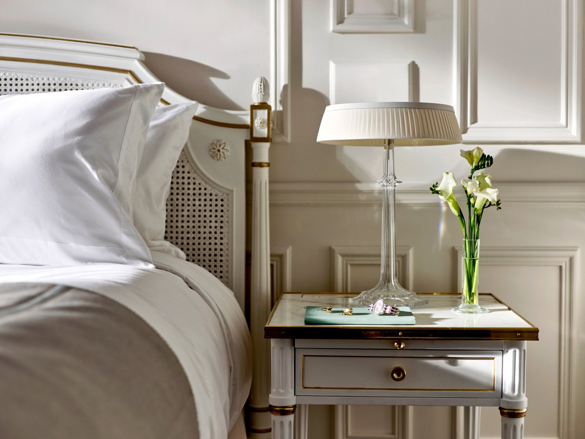 Des bijoux et une montre placés sur la table d’appoint d’une chambre supérieure. Au Meurice, Paris.                                     