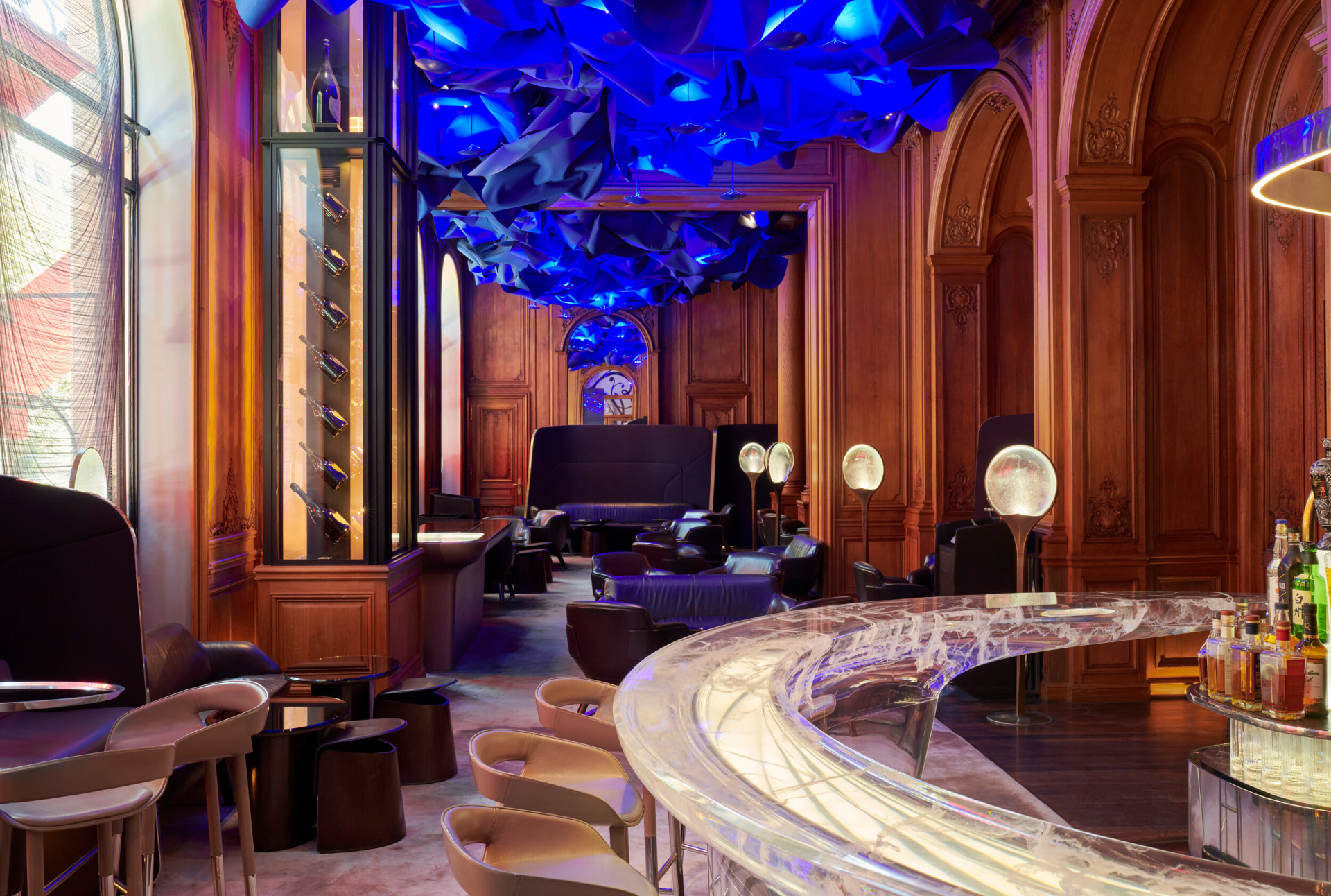 Photo du Bar de l’Hôtel Plaza Athénée, Paris, panneaux de bois, plafond bleu et comptoir transparent