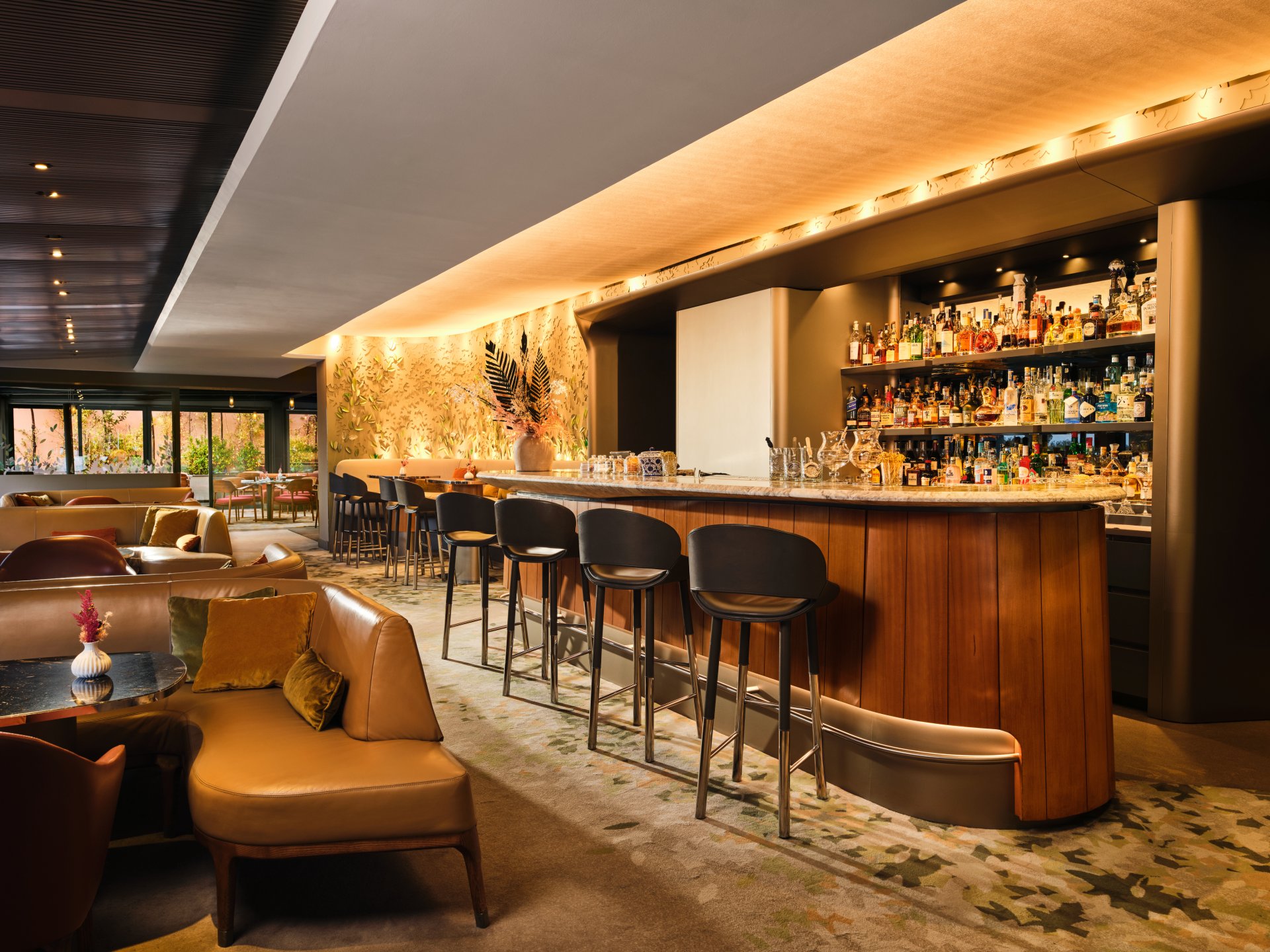 Interno de Il Giardino Bar con lungo bancone illuminato e ampie finestre