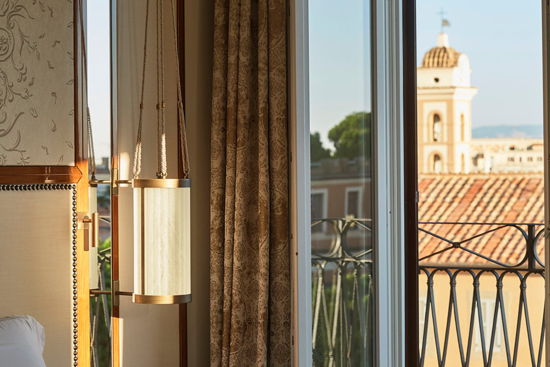 Dettaglio di una camera con finestra aperta su balcone con vista su Roma a Hotel Eden Roma