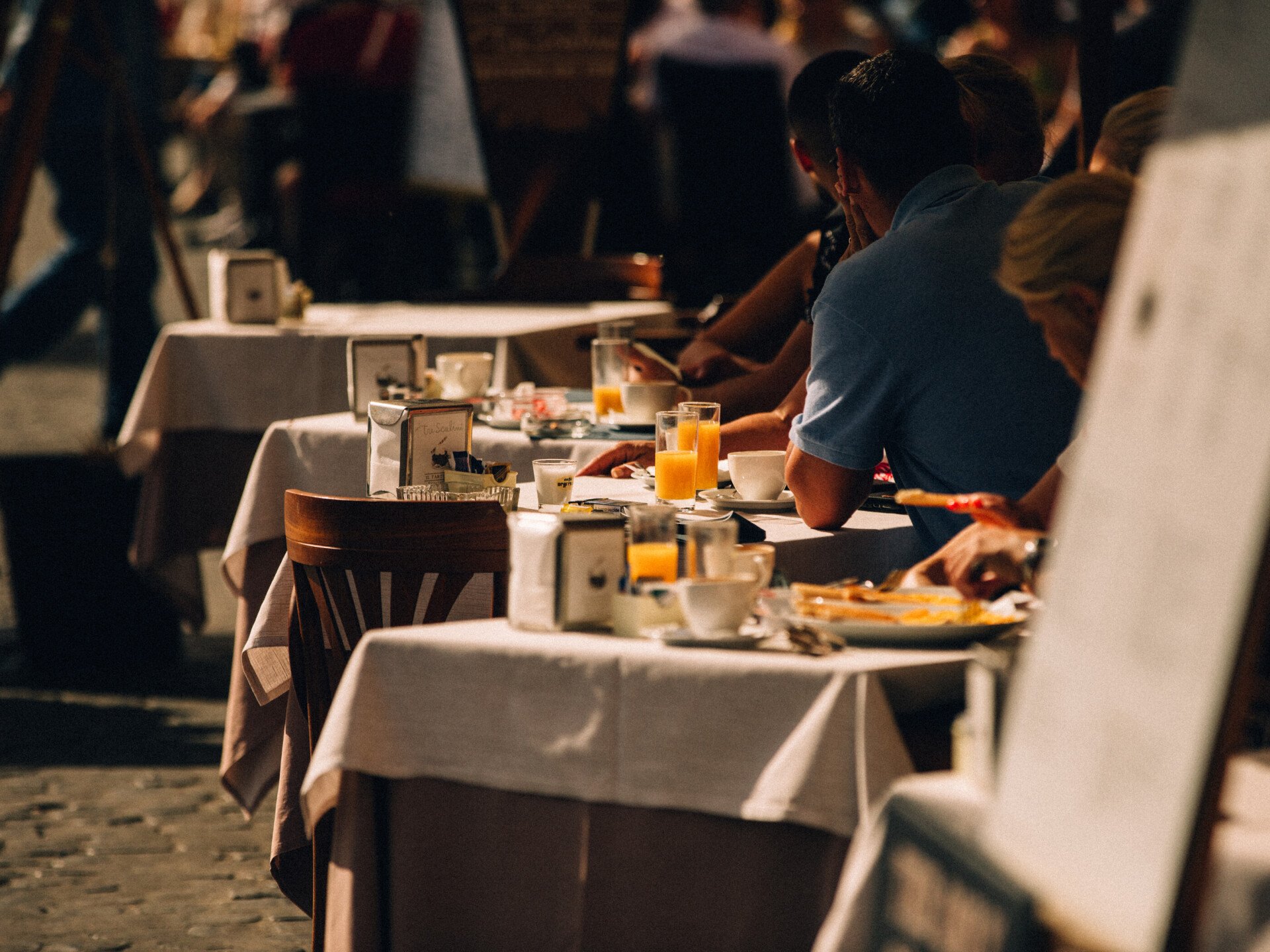 Dettaglio di tavoli con avventori in un caffè di Roma