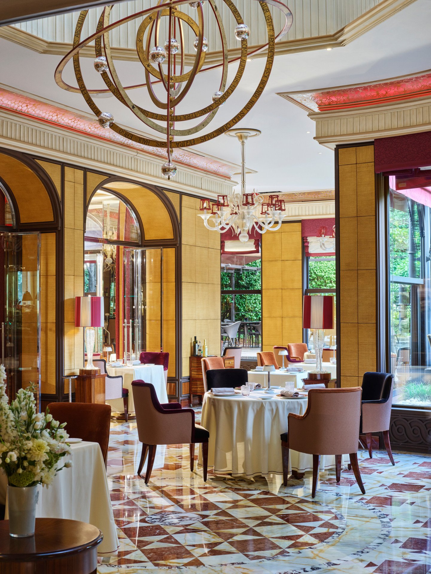 Interni del ristorante Acanto. Tavoli, sedie e il giardino sullo sfondo