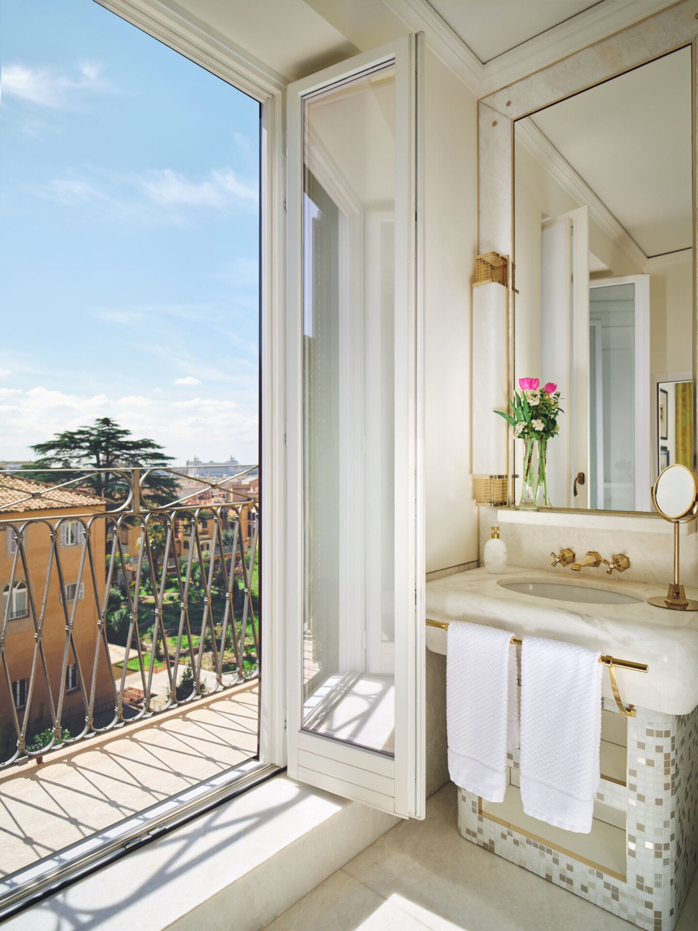bagno con finestra aperta sul balcone in una camera di Hotel Eden Roma