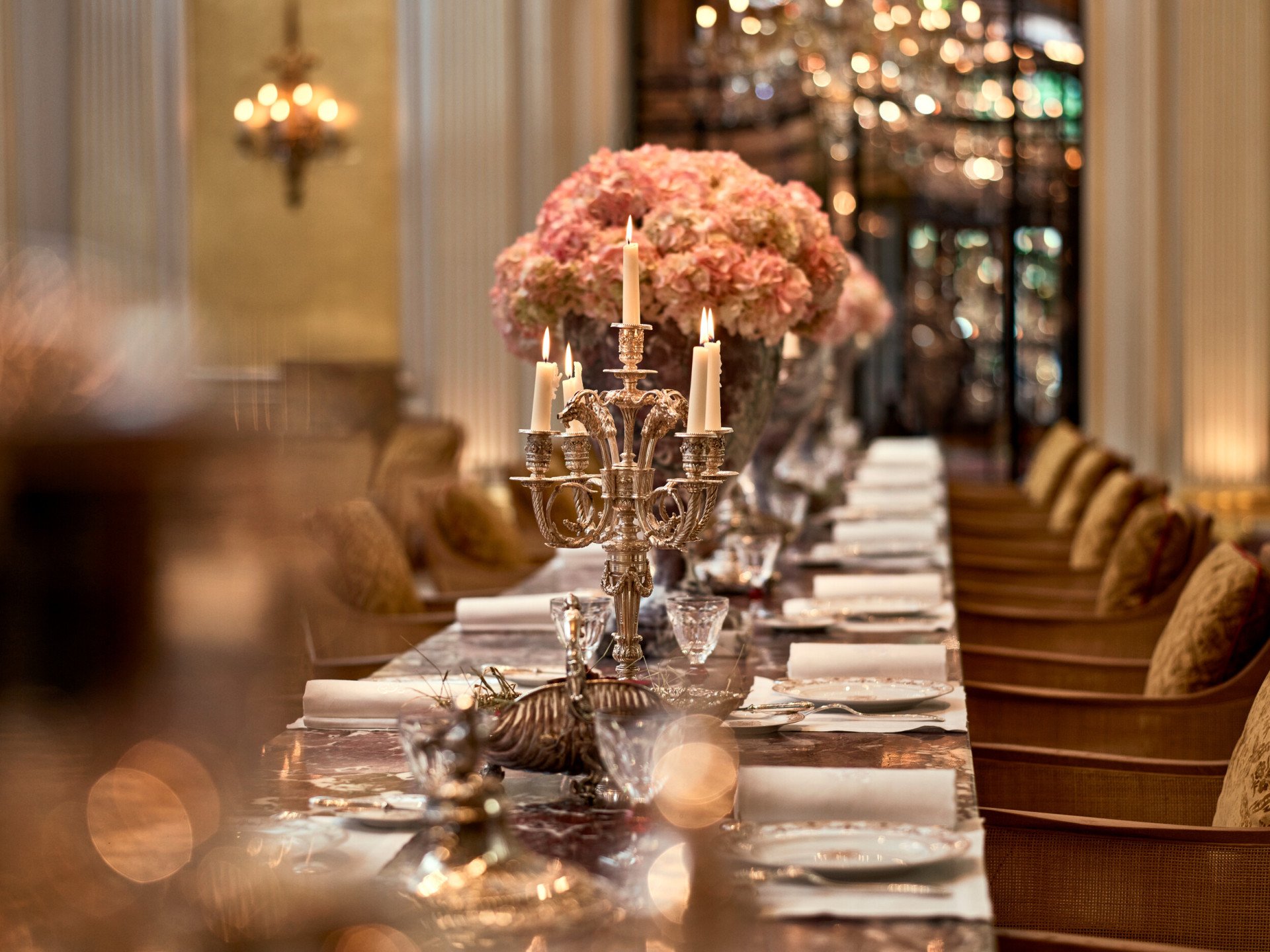 Jean Imbert au Plaza Athénée : la table centrale en marbre, agrémentée de fleurs roses et de chandeliers. A l'hôtel Plaza Athénée, Paris