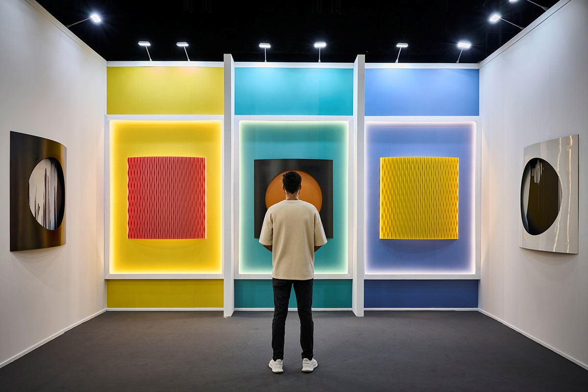 A Man standing in front of some painting during Art Dubai