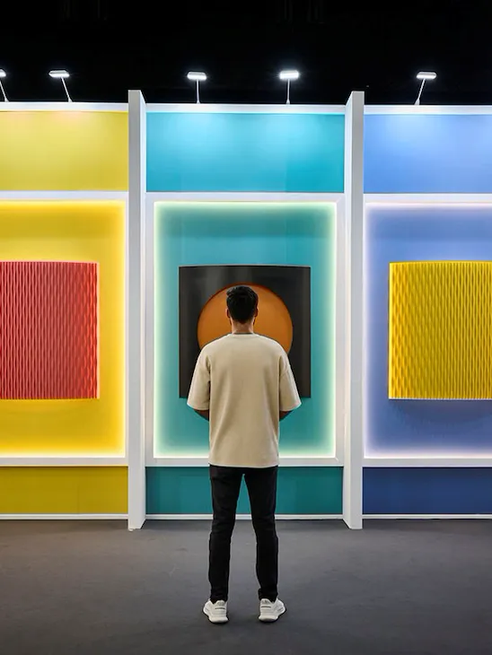 A Man standing in front of some painting during Art Dubai