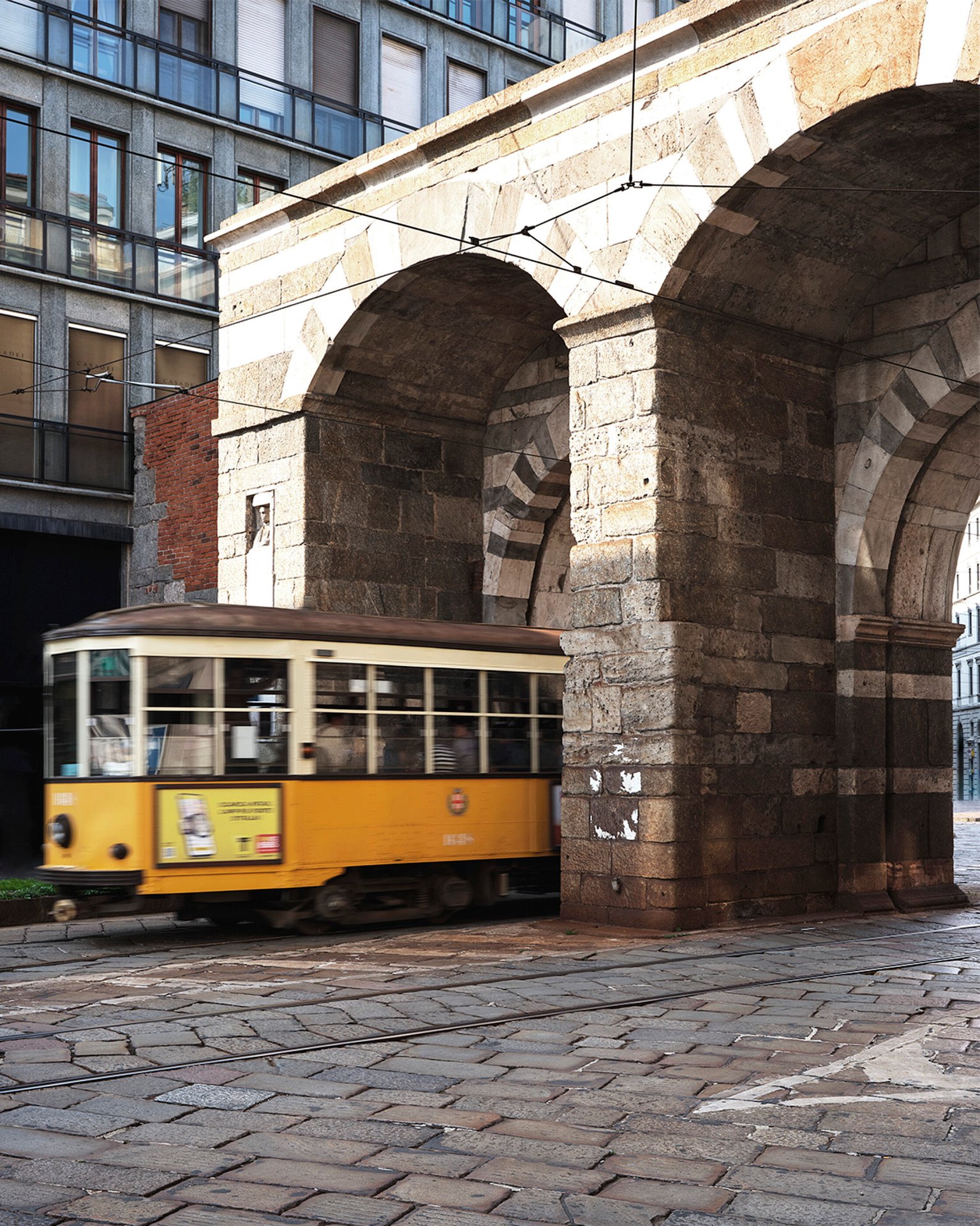 Porta Venezia con un tipico tram giallo in primo piano