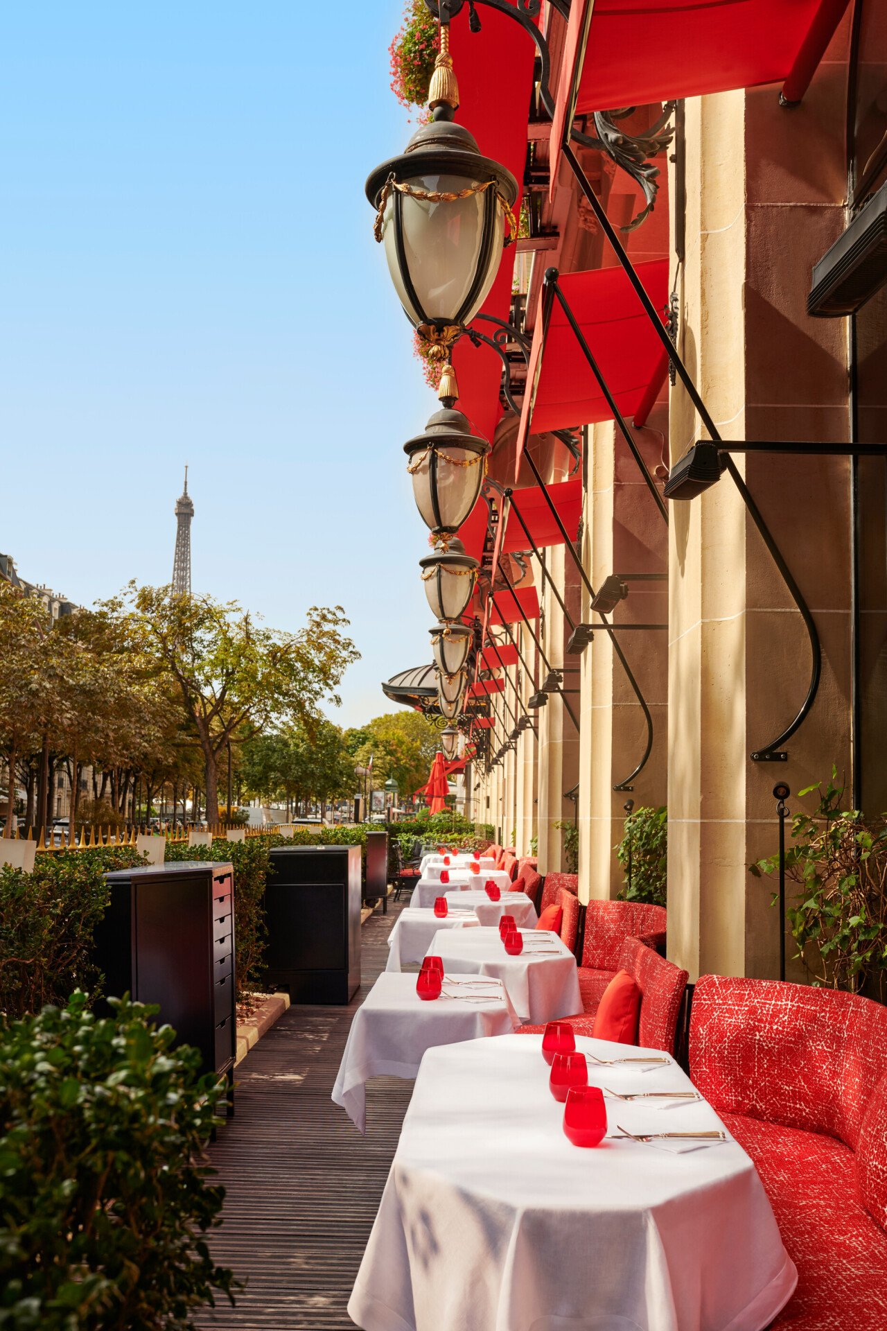 Foto de La Terrasse Montaigne com mesas rebatíveis e assentos vermelhos emblemáticos