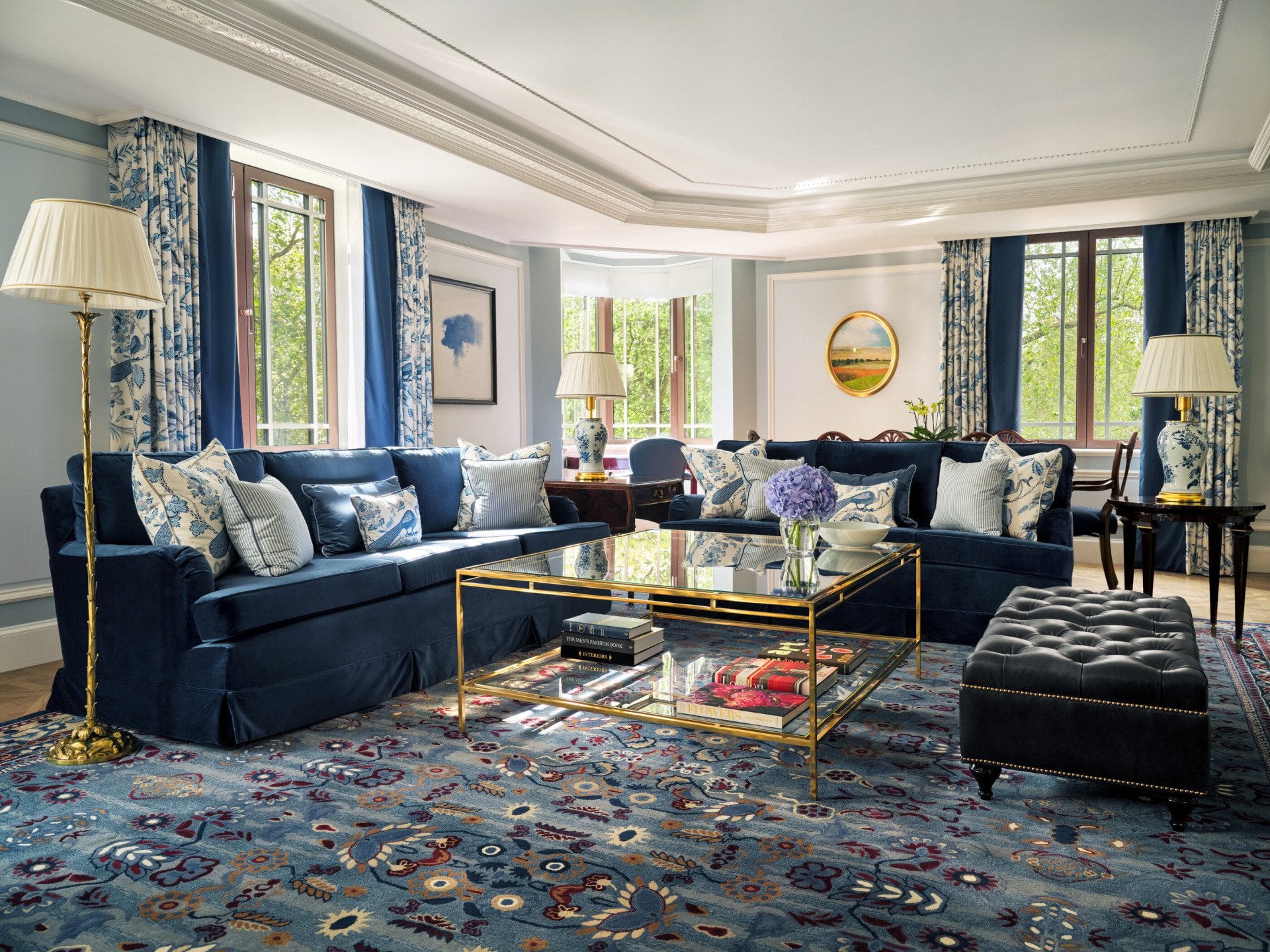 A sophisticated suite with comfortable seating in deep blue and paler tones