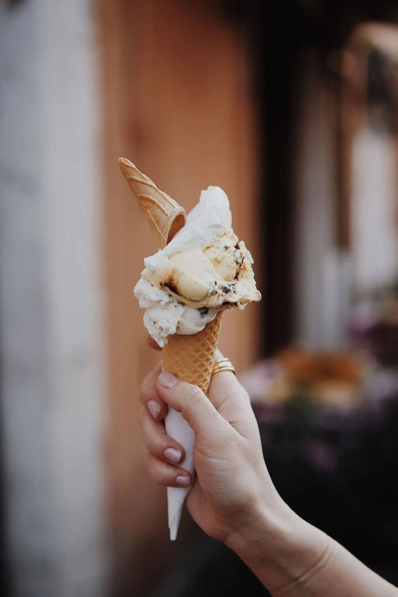 Mano che tiene un cono di gelato