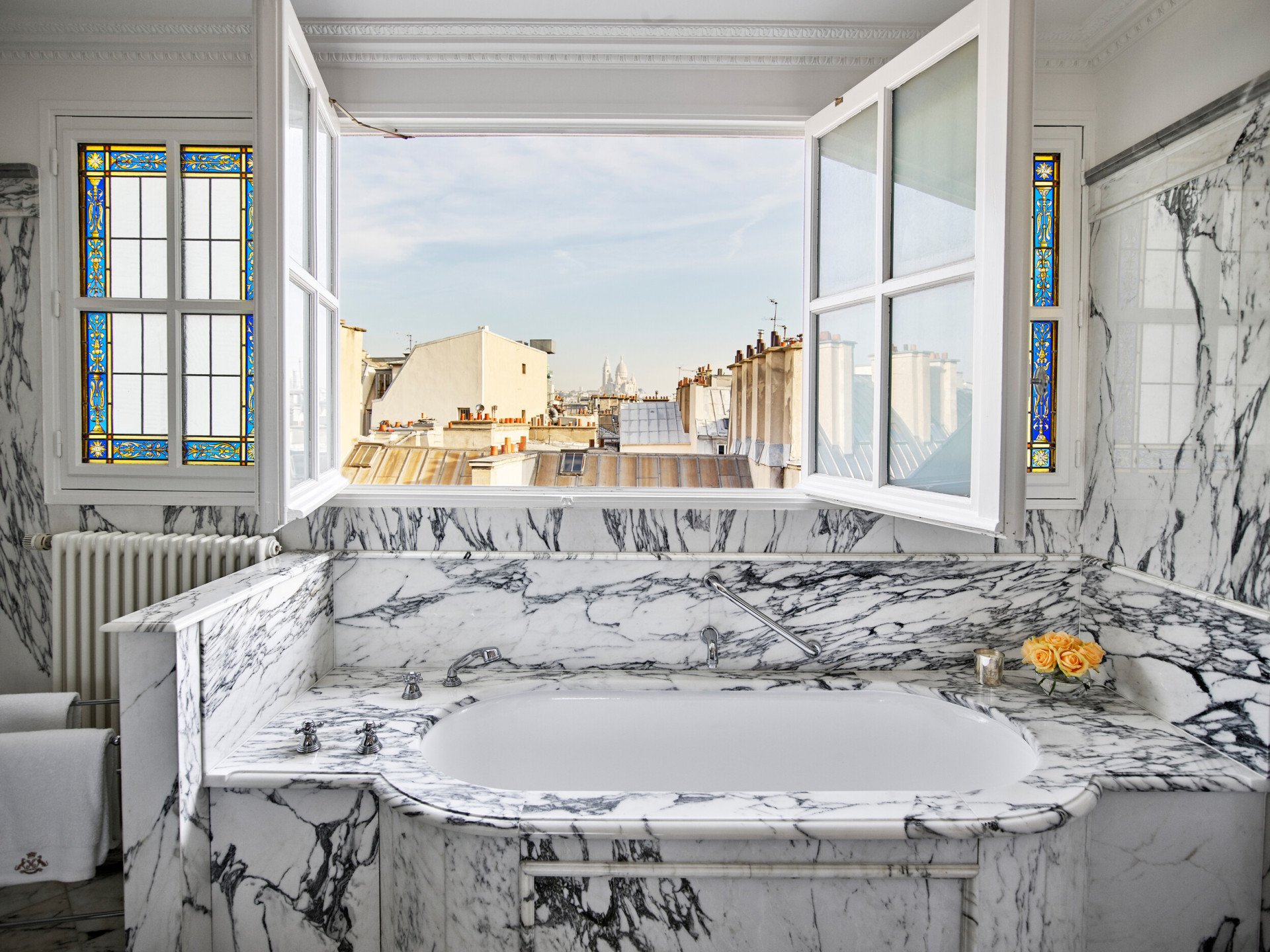Banheiro de mármore com janelas abertas com vista para o horizonte de Paris em suíte júnior executiva no Le Meurice, Paris.