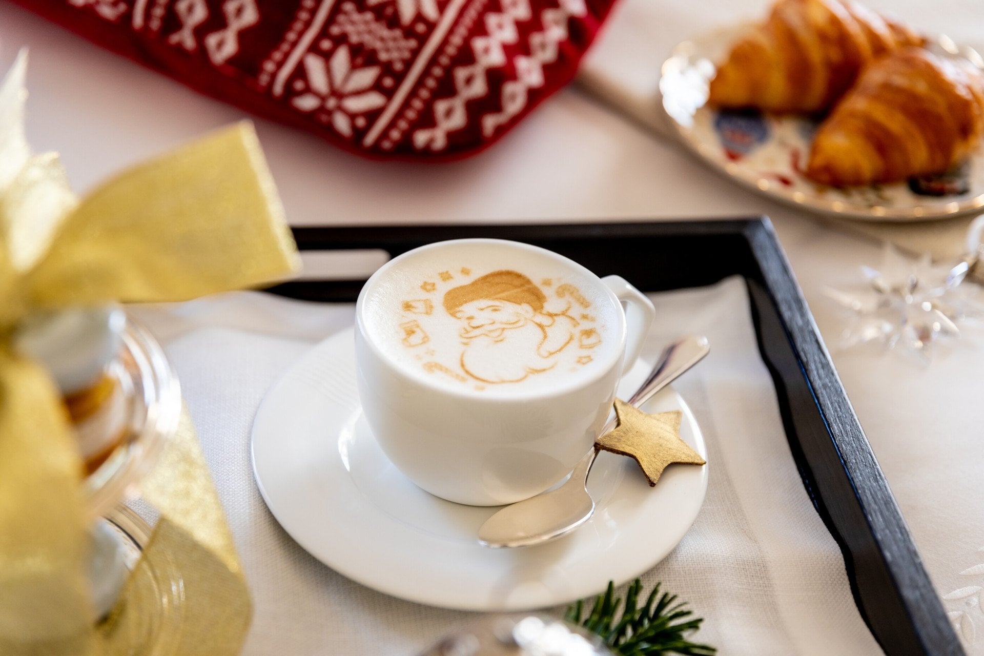 Colazione natalizia con cappuccino con immagine di Babbo natale e varie decorazioni