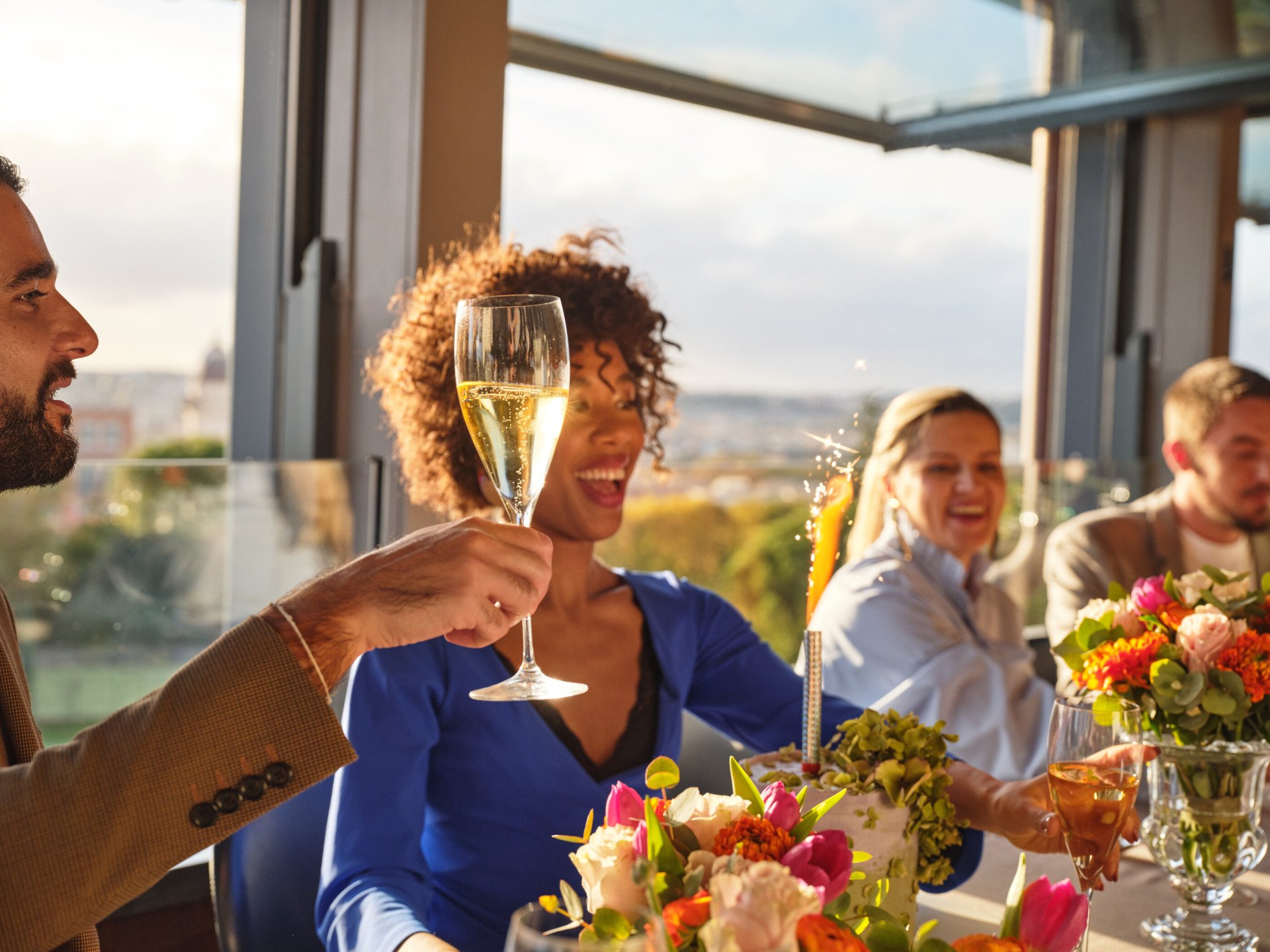 persone sedute ad un tavolo de La Terrazza che festeggiano un compleanno con torta e brindando