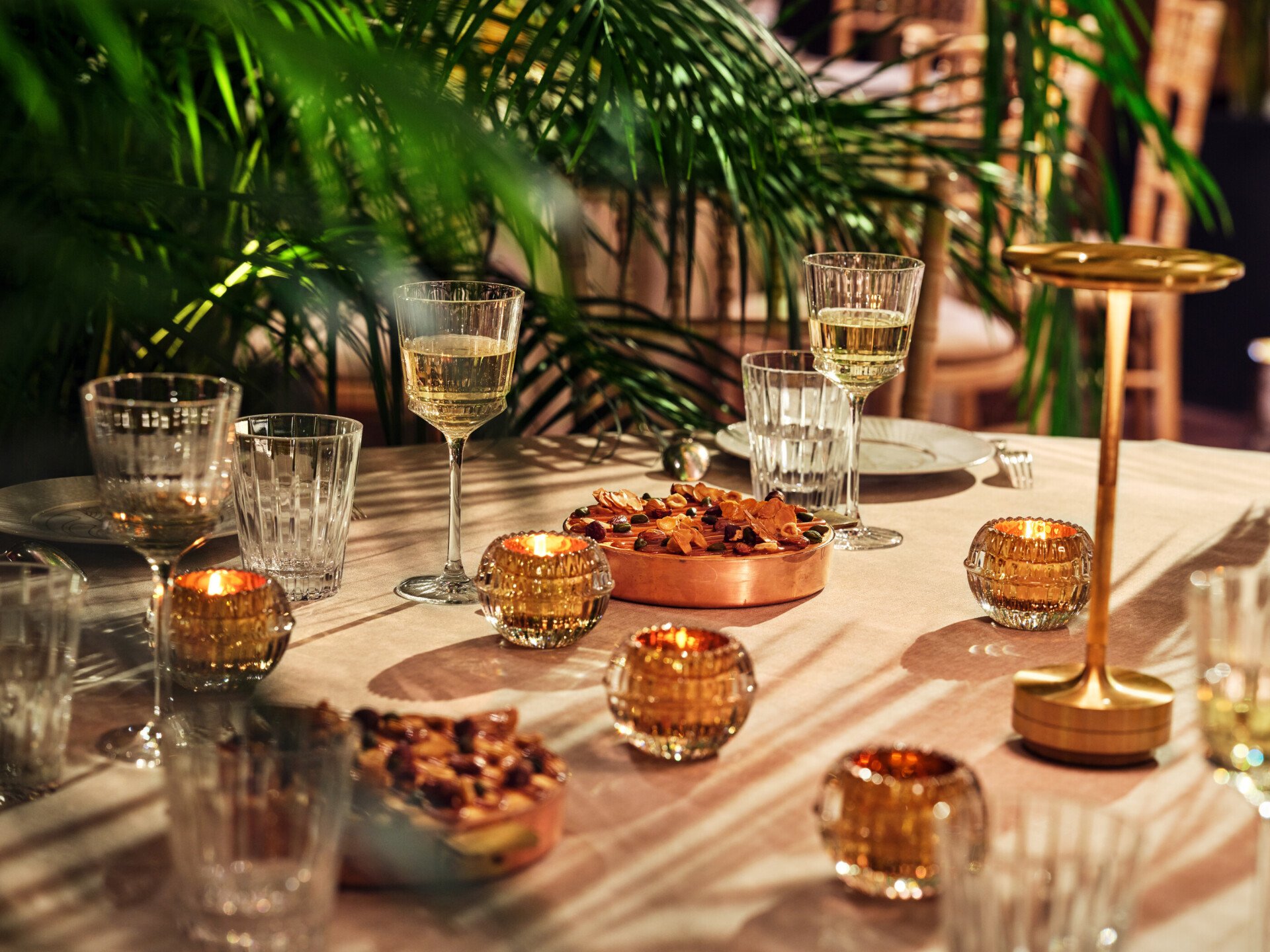 Dinner set up with round tables and palm treescaptured in Le Salon Haute Couture, at Hôtel Plaza Athénée, Paris - Dorchester Collection.