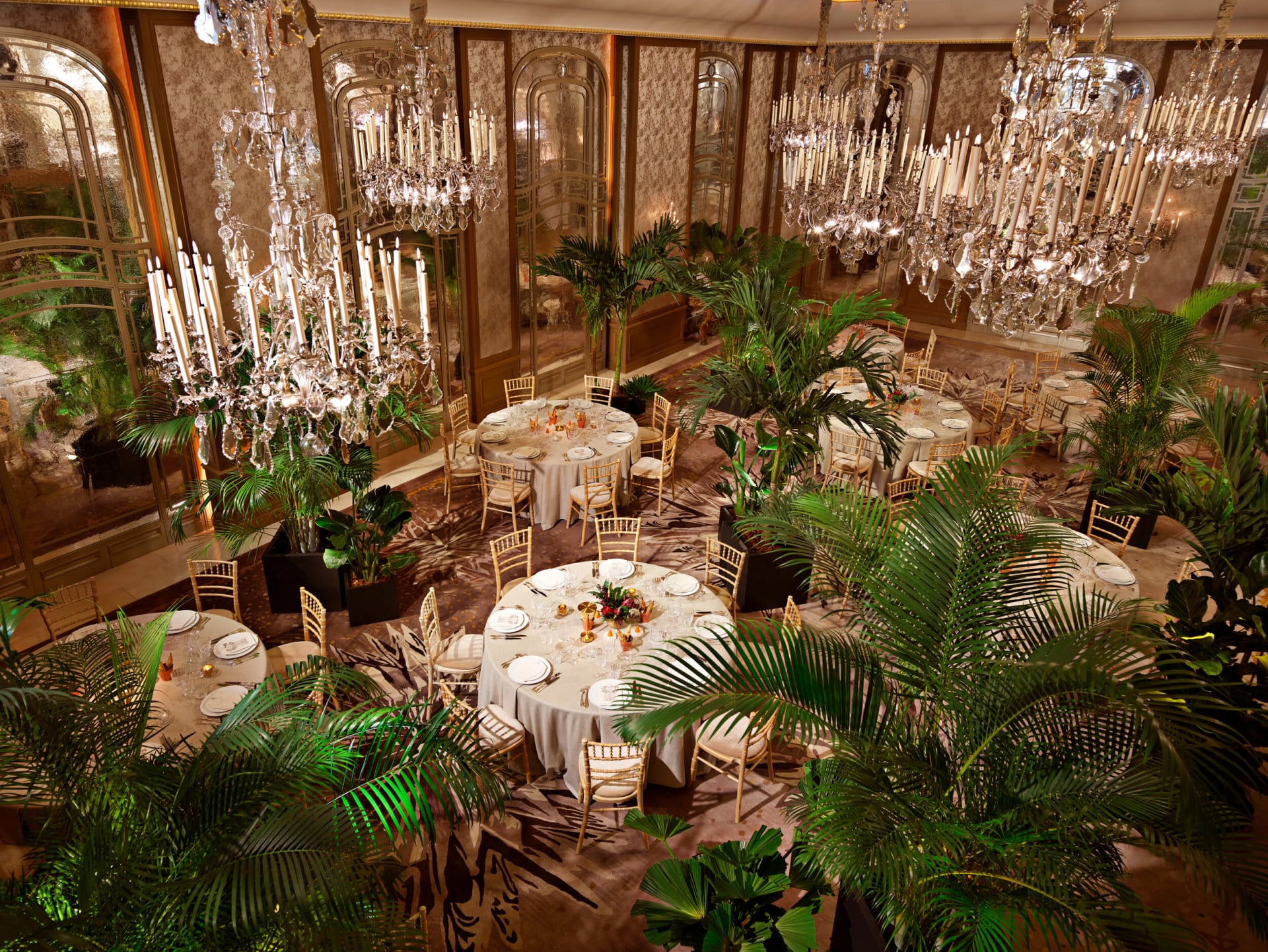 Dîner autour de tables rondes et de palmiers au Salon Haute Couture, à l’Hôtel Plaza Athénée, Paris - Dorchester Collection.