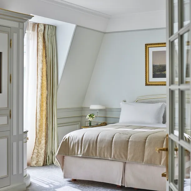 Quarto de uma suite júnior em tons de verde claro e bege no Le Meurice, Paris.