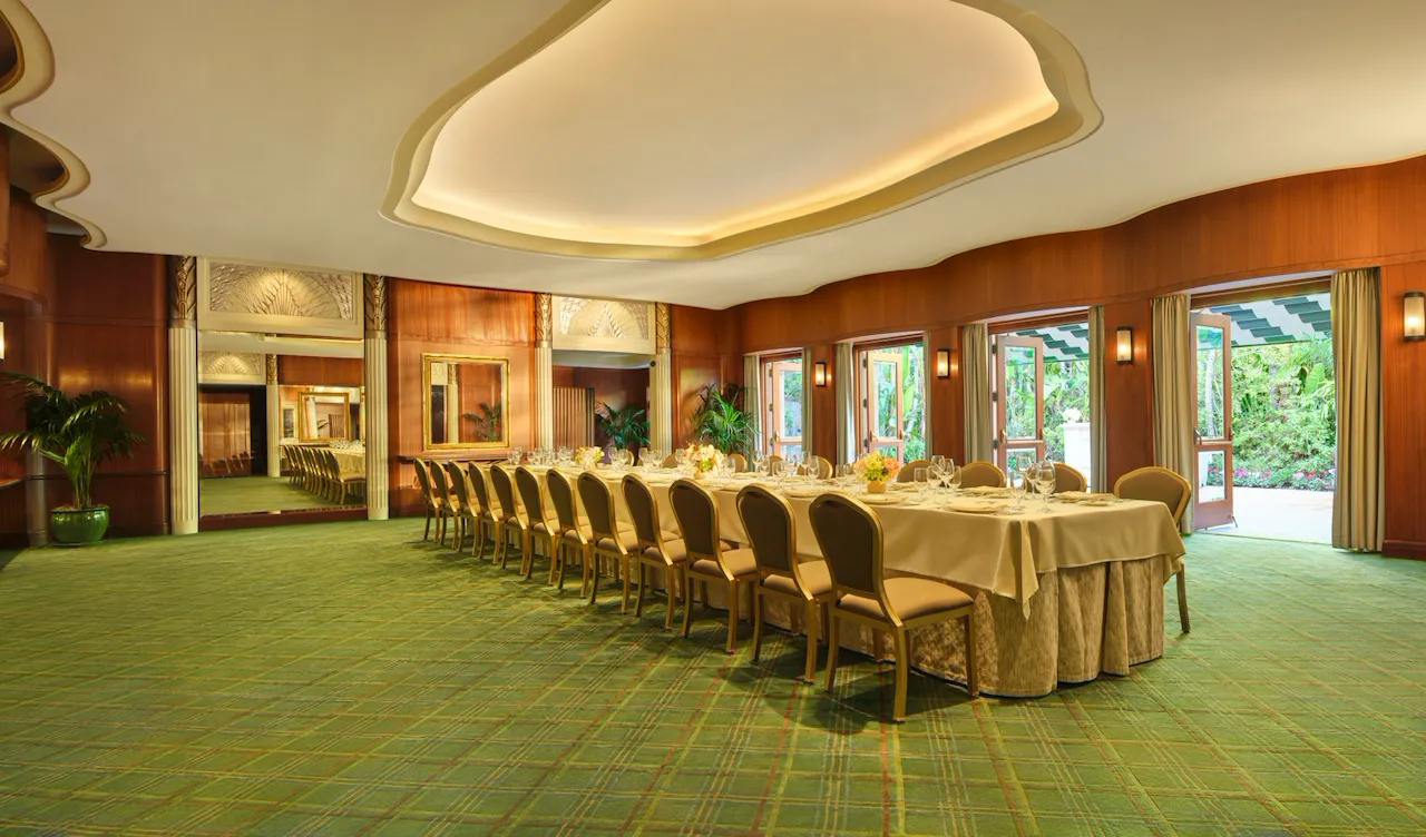 Empty banquet room with a long table set for a meal in a bright, elegant setting