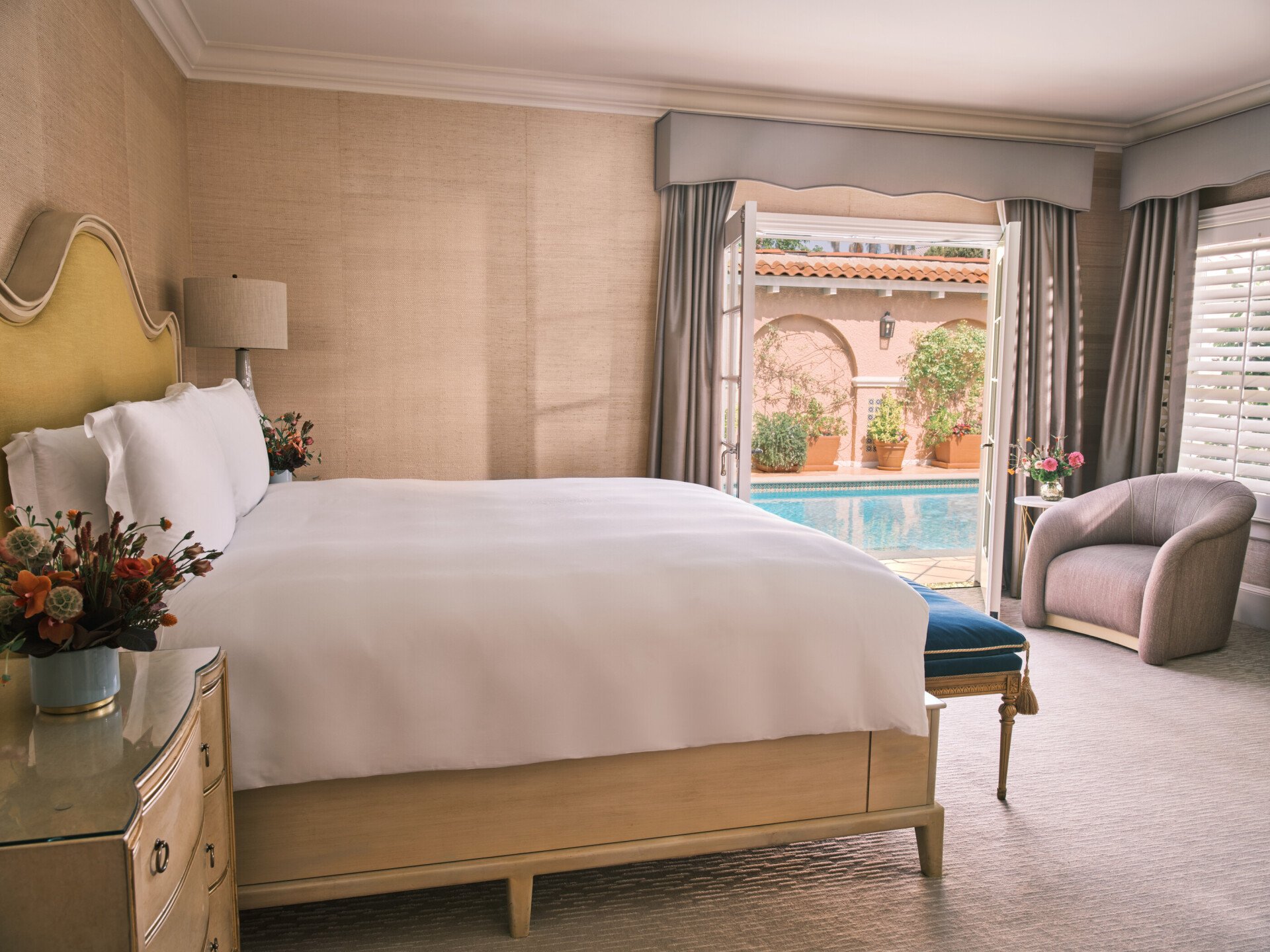 King size bed and private patio entrance to pool in bedroom of legendary bungalow at The Beverly Hills Hotel 