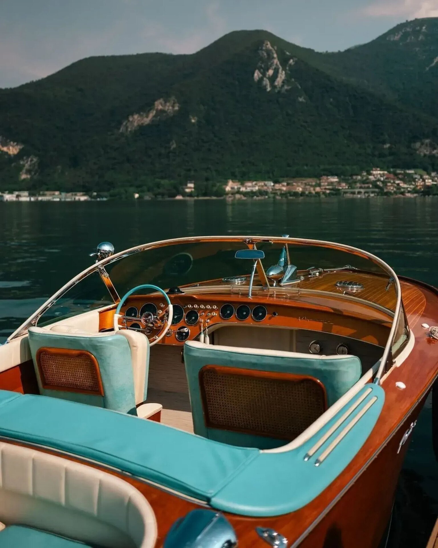 Riva boat in the foreground on Lake Iseo, with the shores and hills in the background.