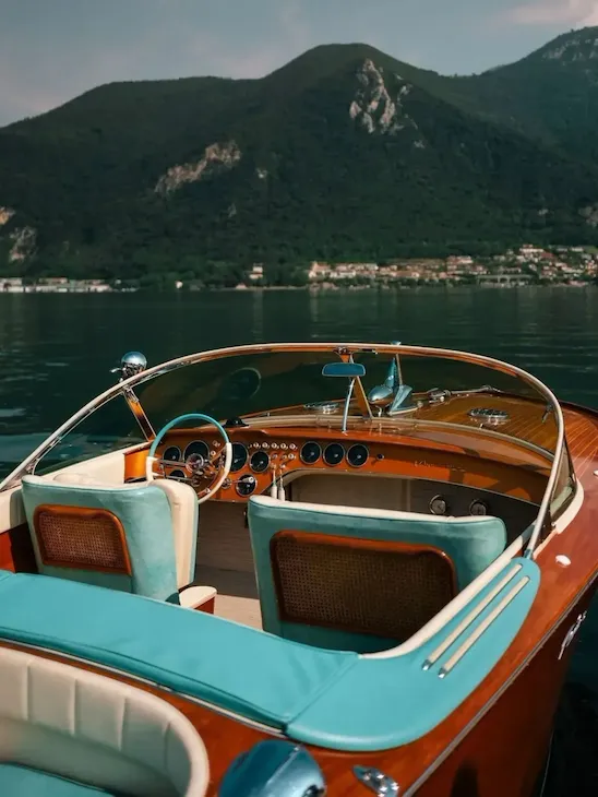 Riva boat in the foreground on Lake Iseo, with the shores and hills in the background.